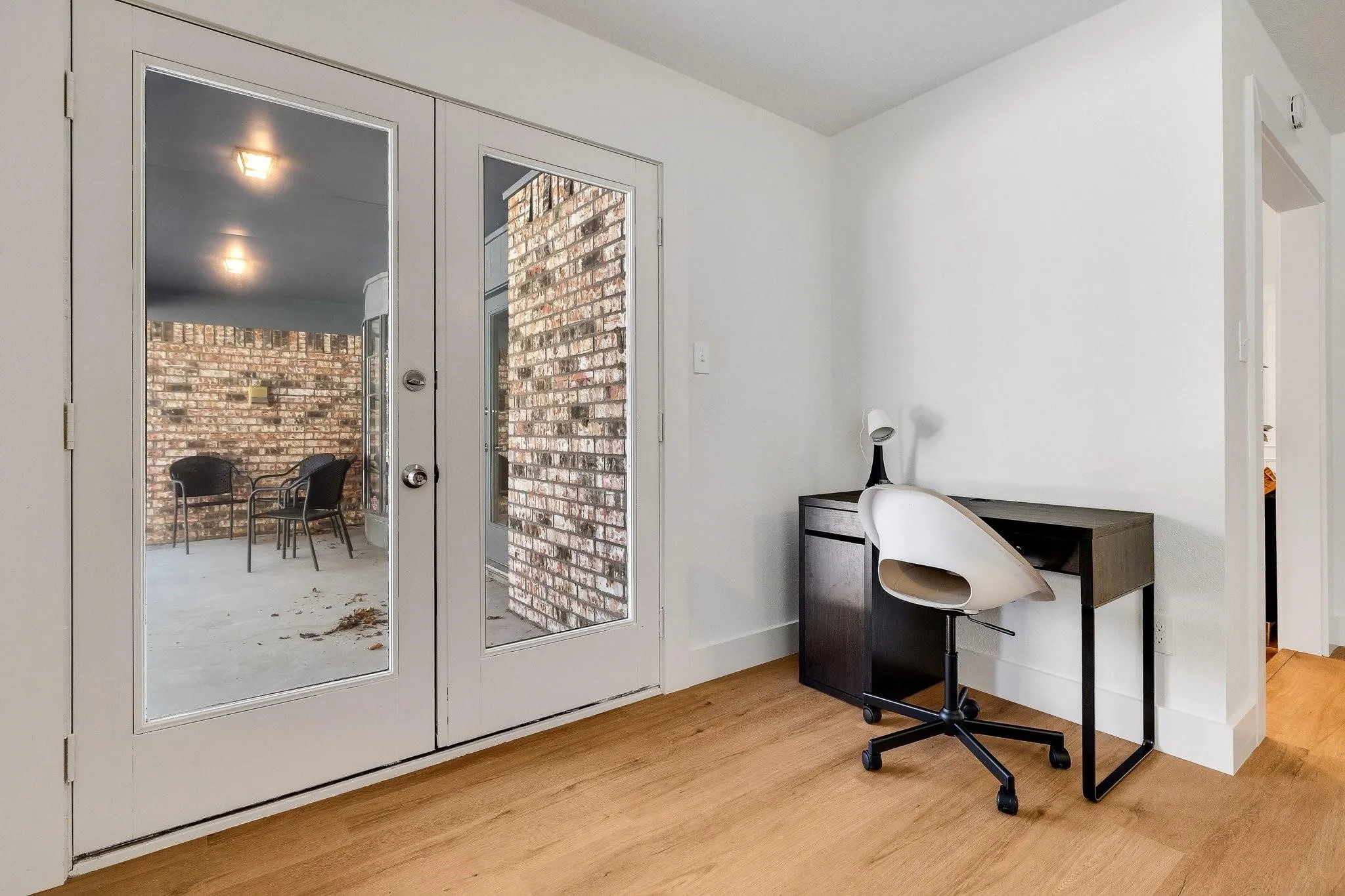 Wood-finish flooring with white baseboards and an arched doorway