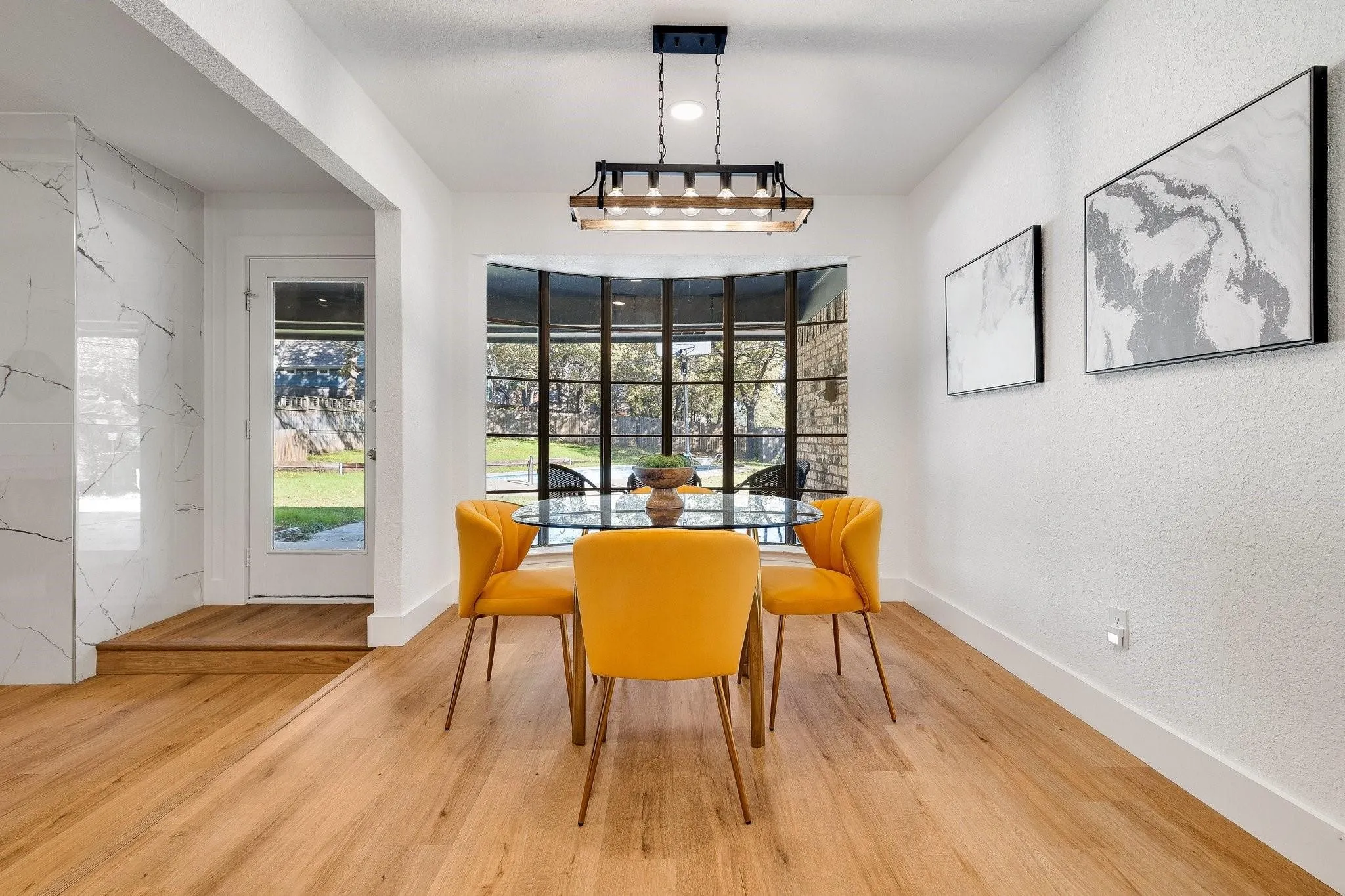 Wood-finish flooring, bay window with dark trim, recessed lighting, and a modern industrial-style chandelier