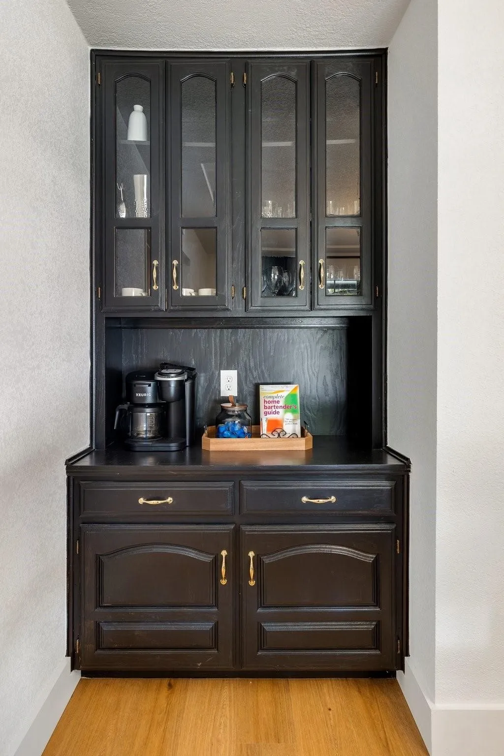 Built-in cabinetry with glass-front upper doors, lower storage cabinets, and a counter workspace