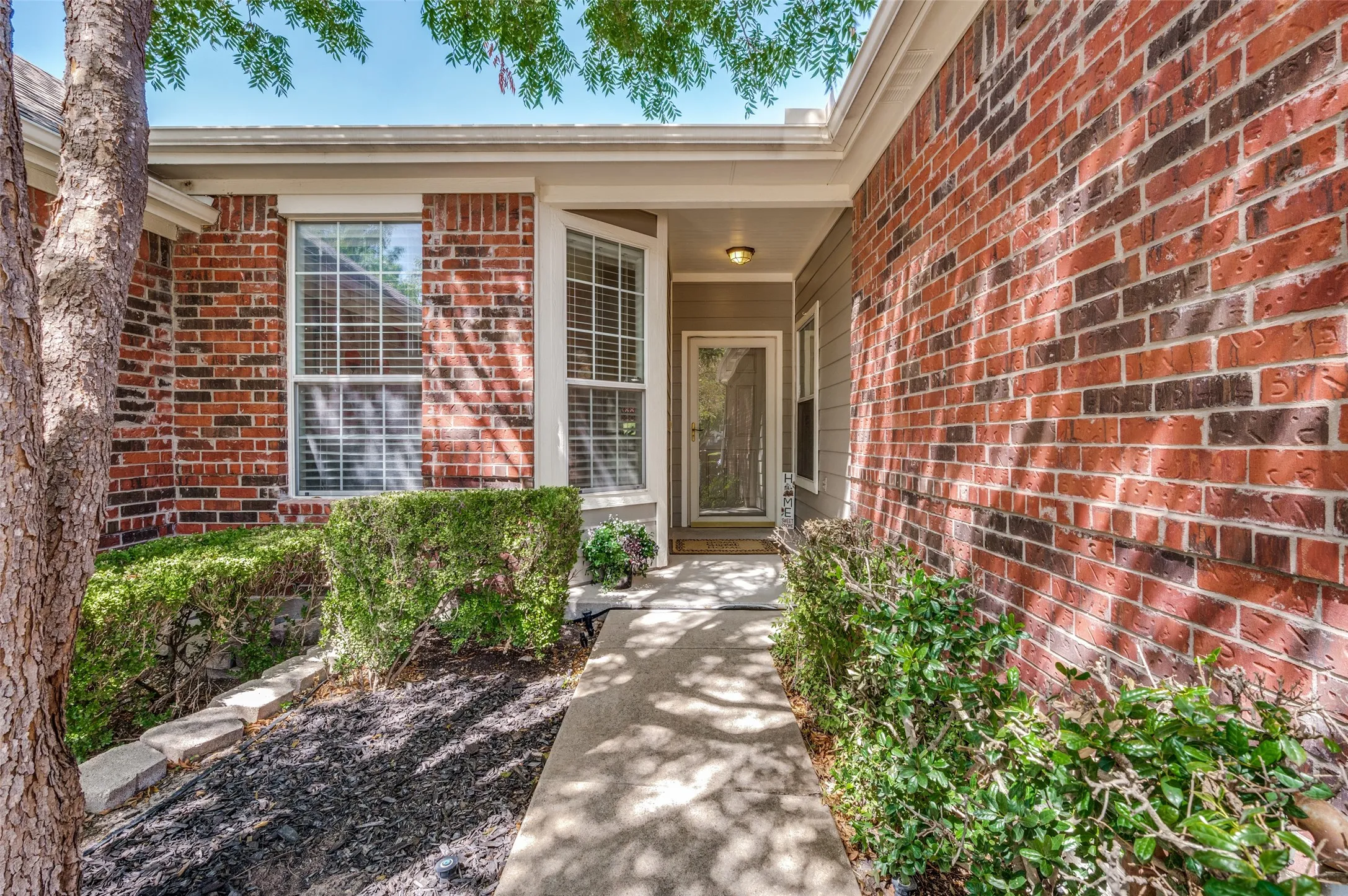 Brick exterior with siding accents and a concrete pathway