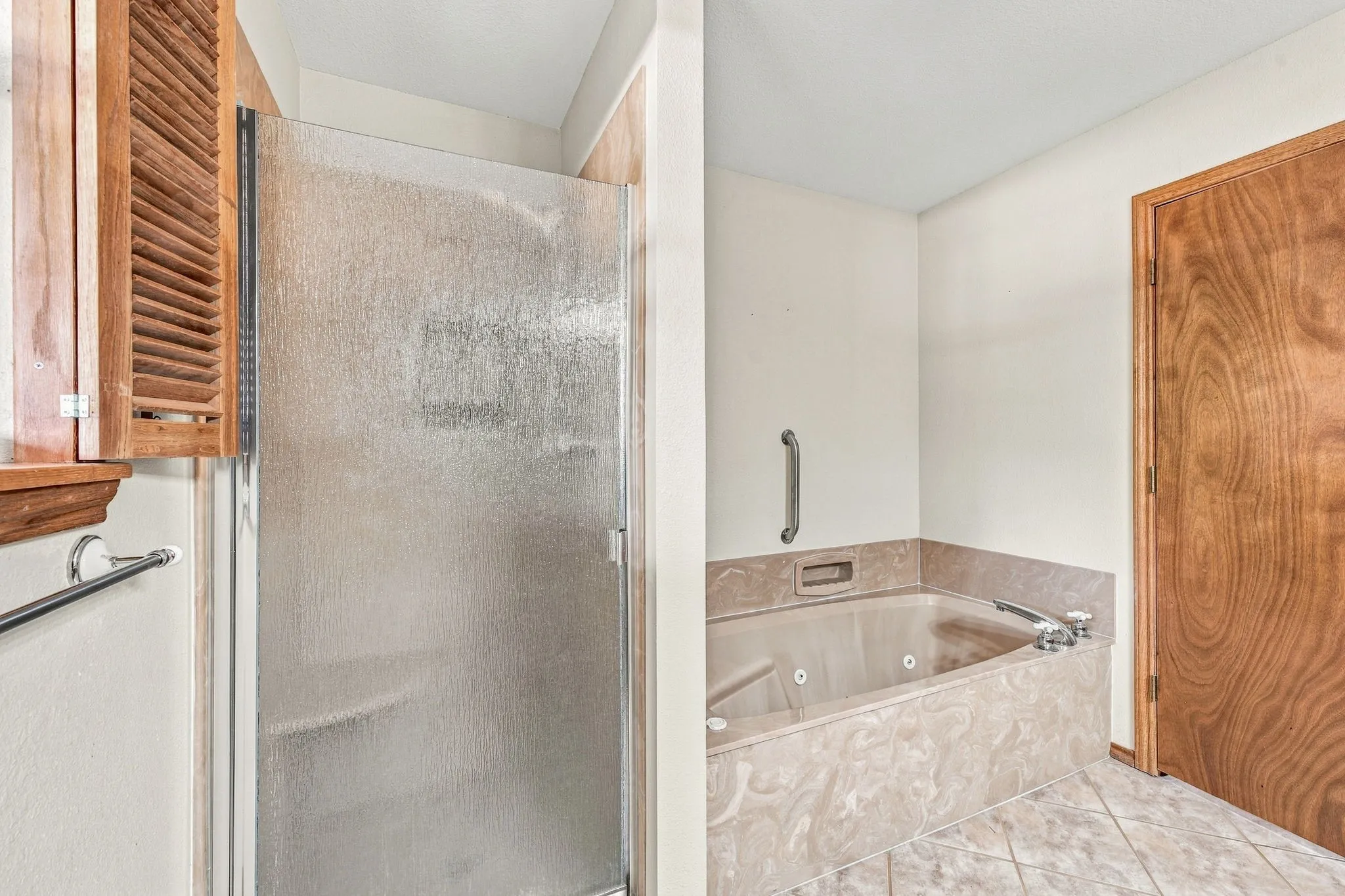 Enclosed shower with textured glass and a wood-finish cabinet