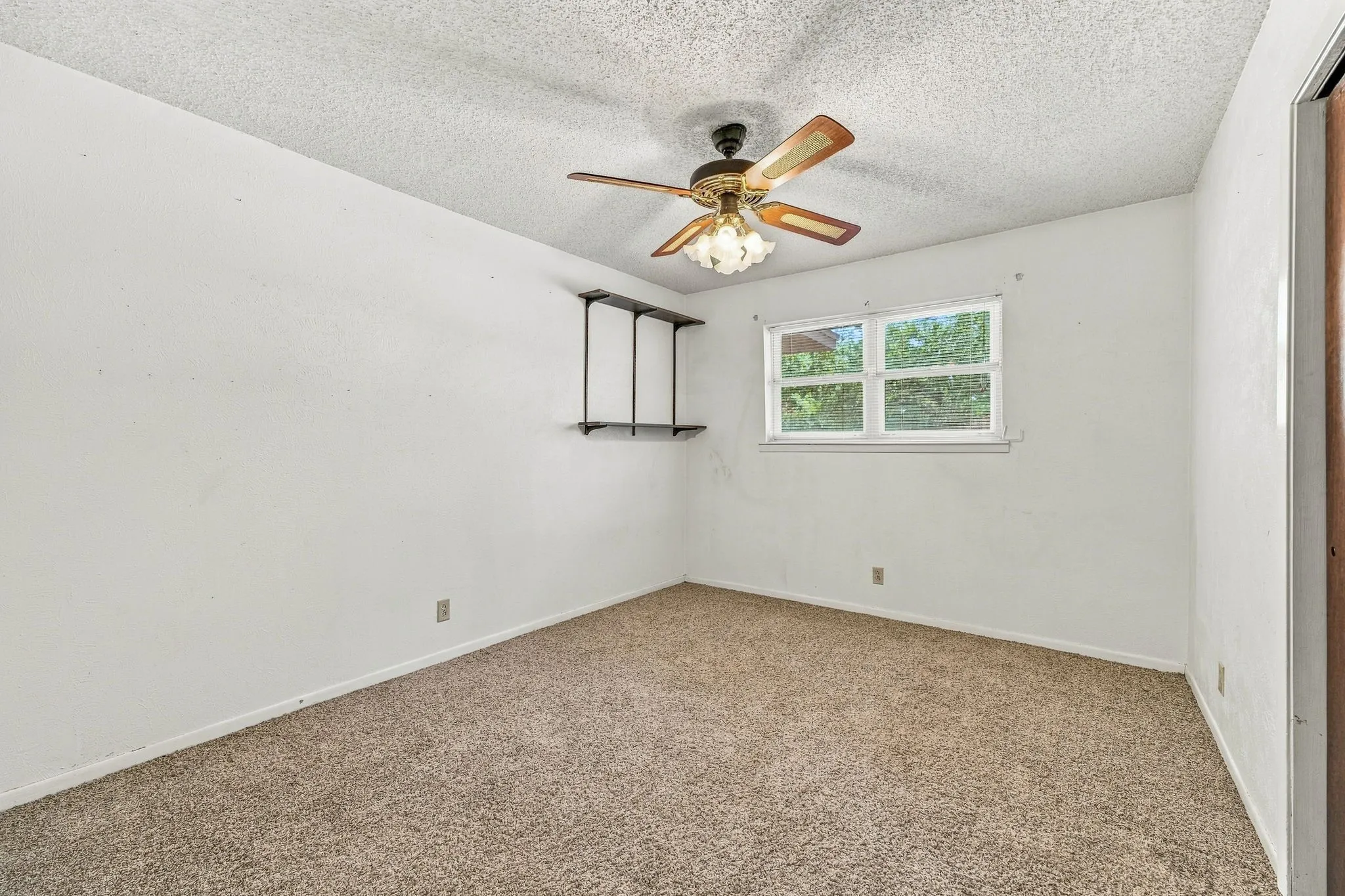 Carpeted flooring, white walls, and a ceiling fan with integrated lighting