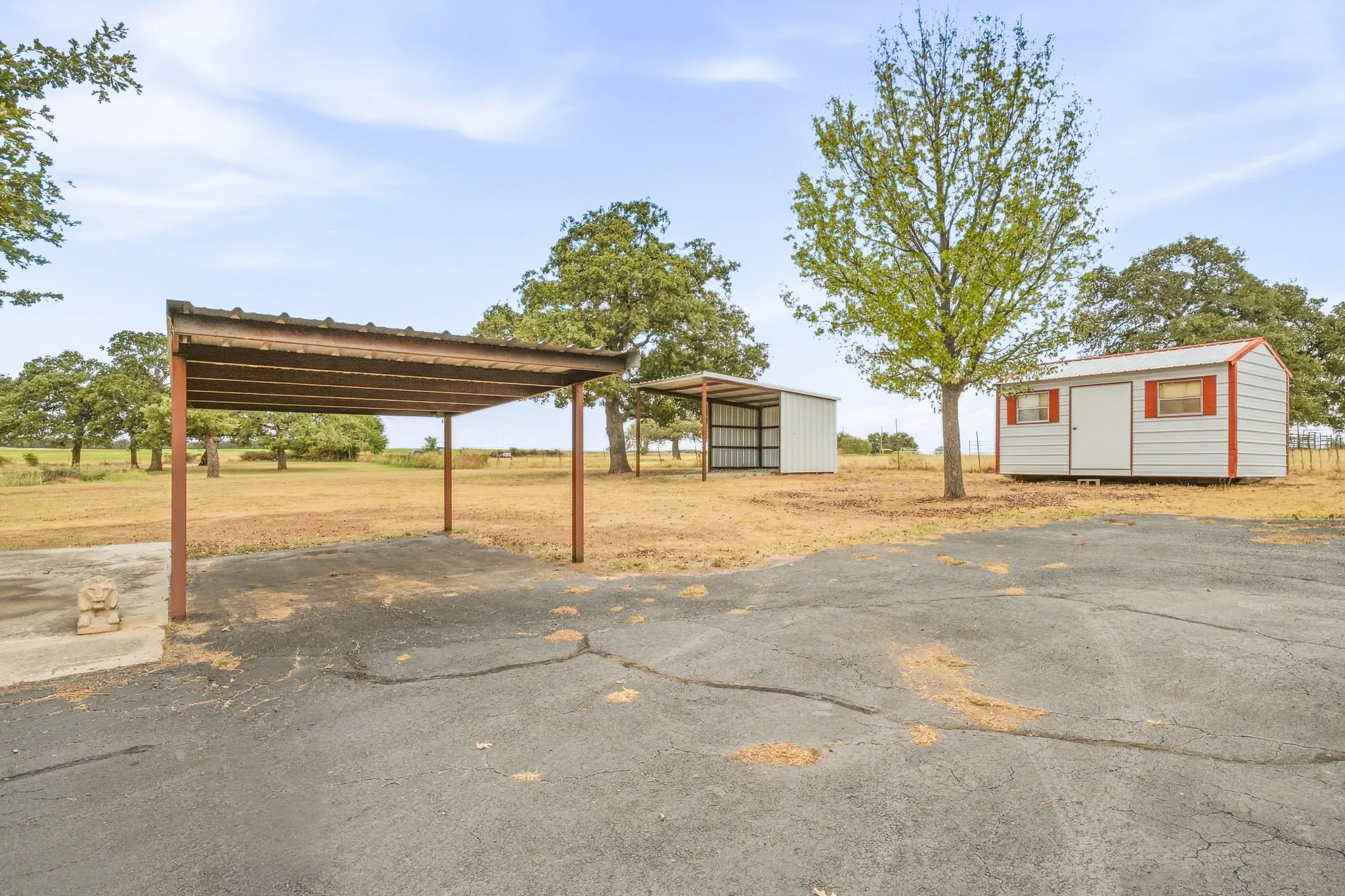 Covered parking structure, two outbuildings, and expansive open land