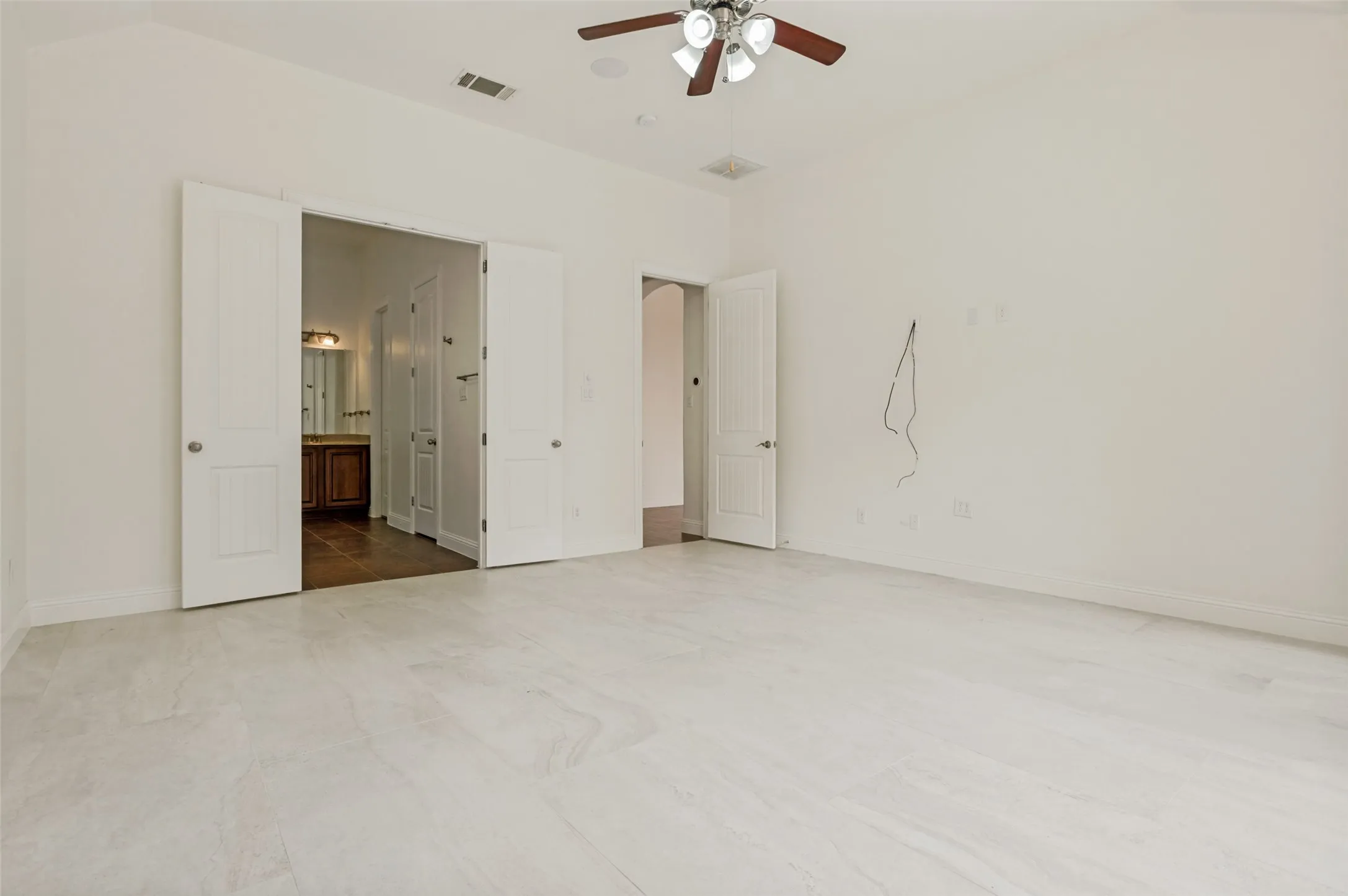 Spacious room featuring light-toned tile flooring and crisp white walls