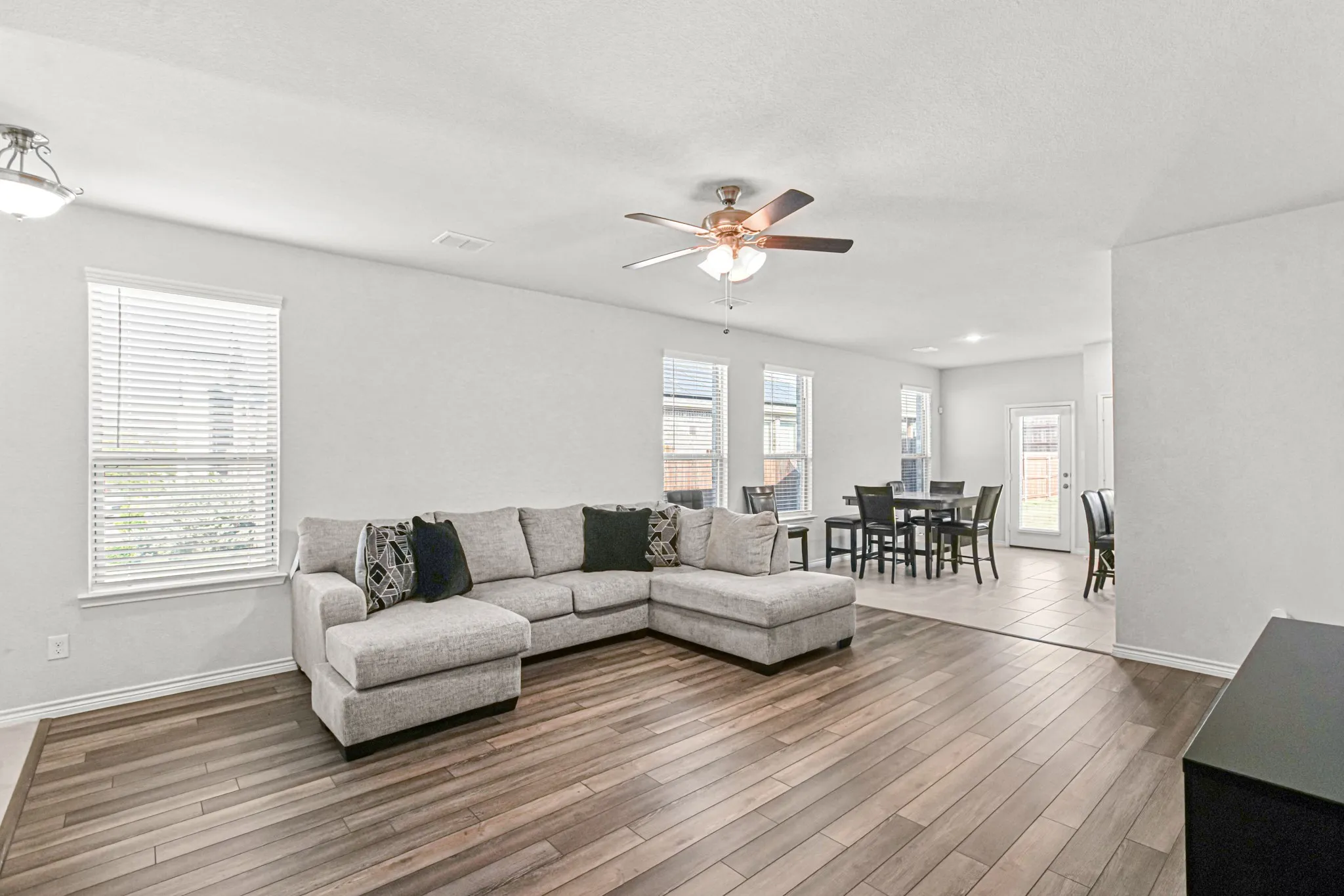 Wood-finish flooring, recessed lighting, and a ceiling fan with integrated light fixture