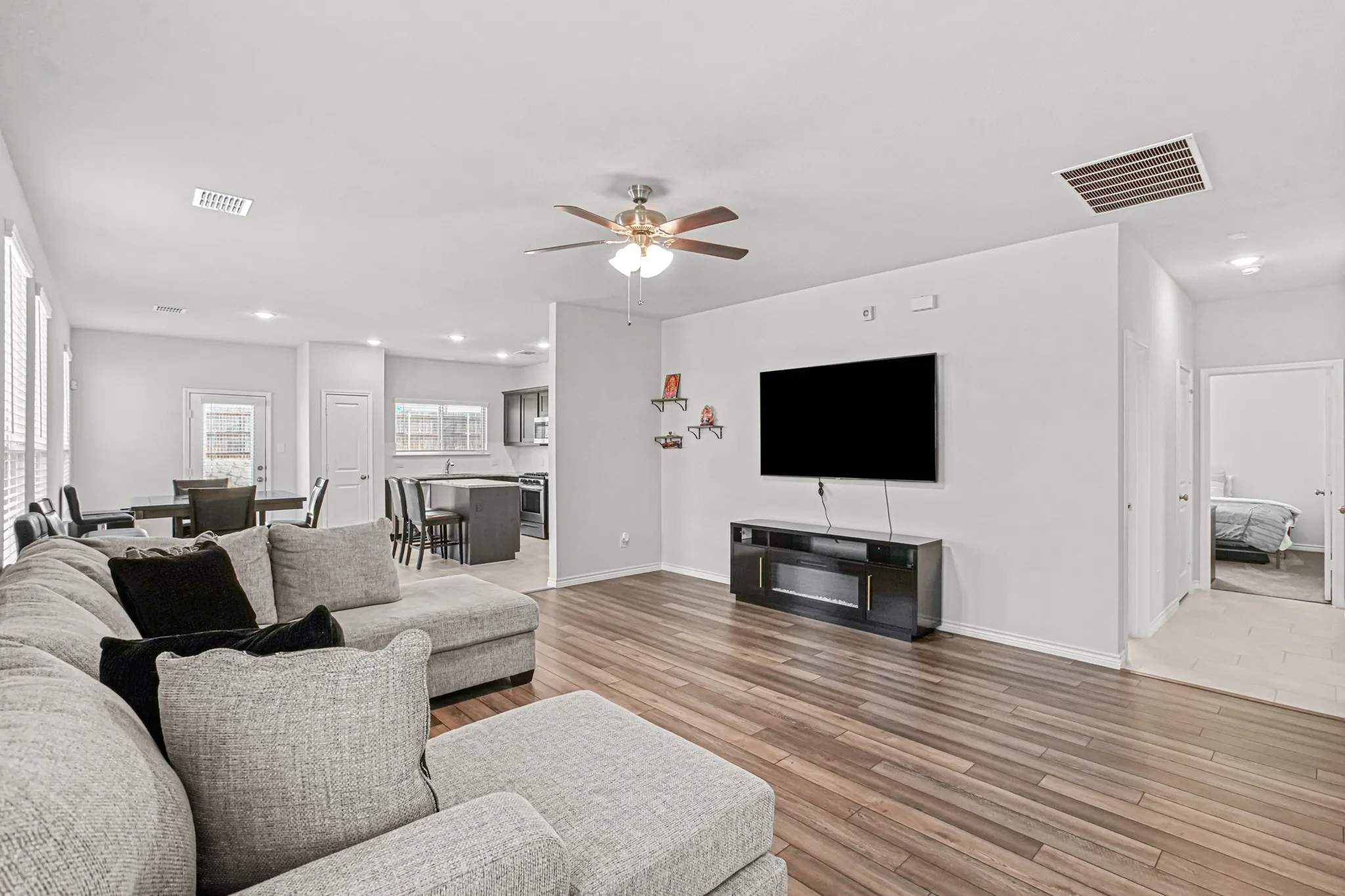 Open-concept living space featuring wood-finish flooring, recessed lighting, and a ceiling fan