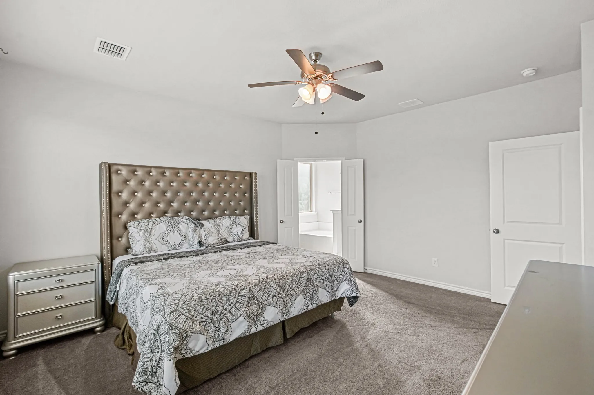 Plush carpeting, ceiling fan with integrated lighting, and white interior doors