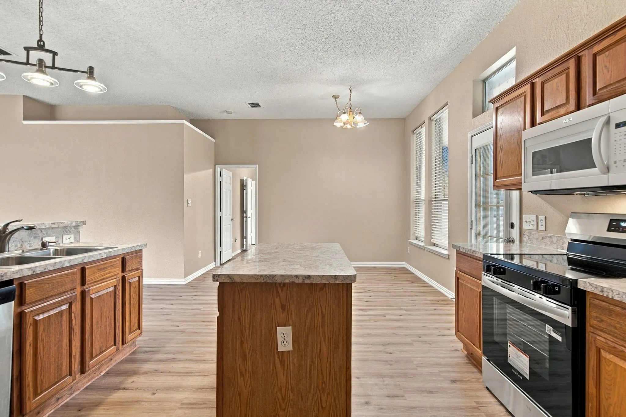 Kitchen featuring wood-finish flooring, a central island, and wood cabinetry
