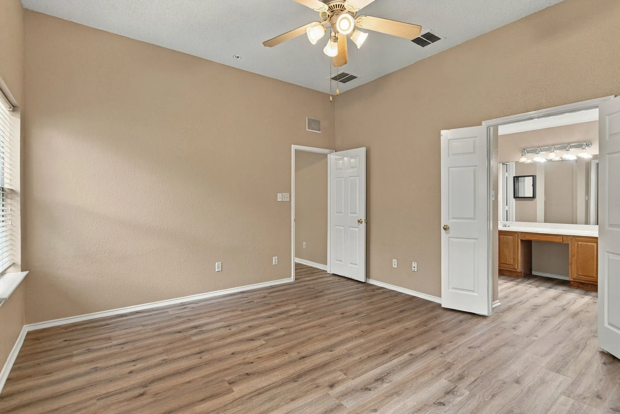 Vaulted ceilings, wood-finish flooring, and a ceiling fan with integrated lighting