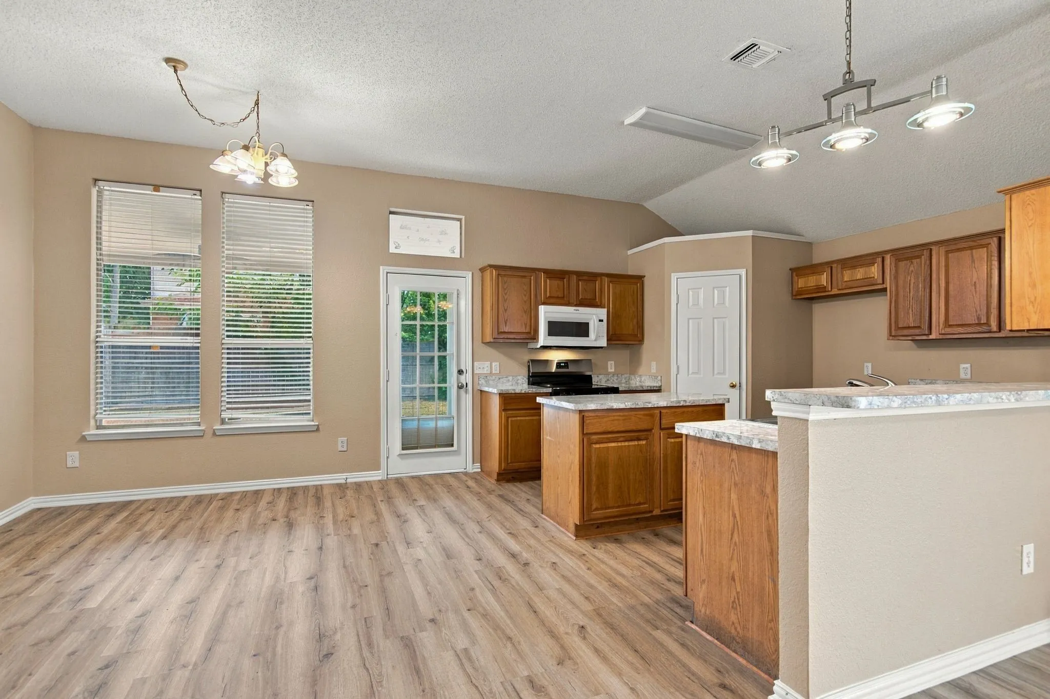 Kitchen area featuring wood-finish flooring, vaulted ceiling, and recessed lighting