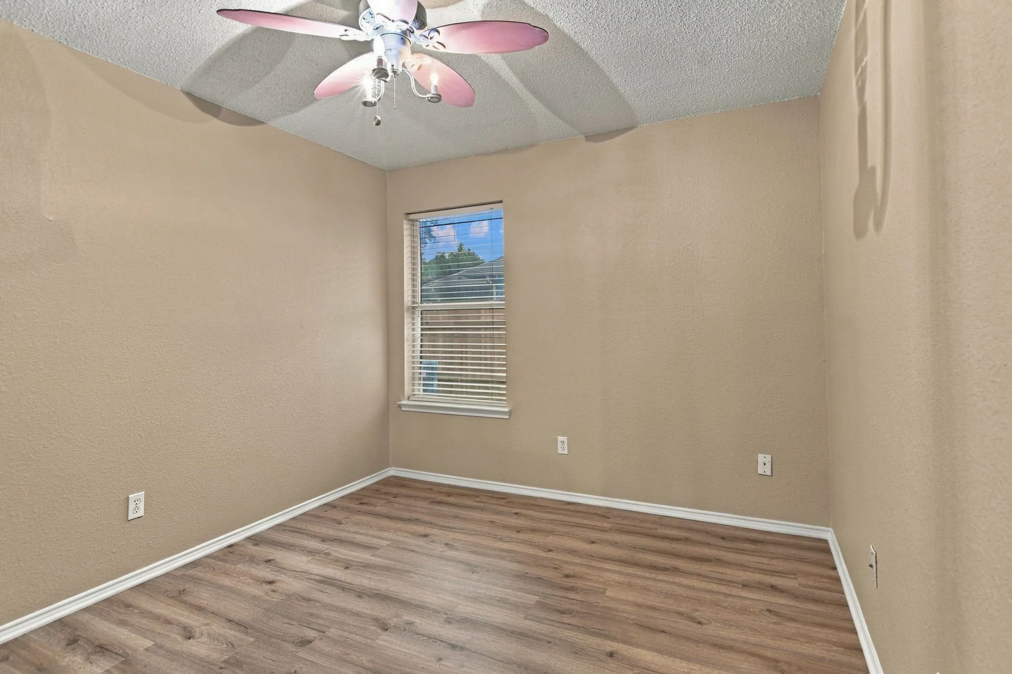 Wood-finish flooring, neutral-toned walls, and a window with blinds