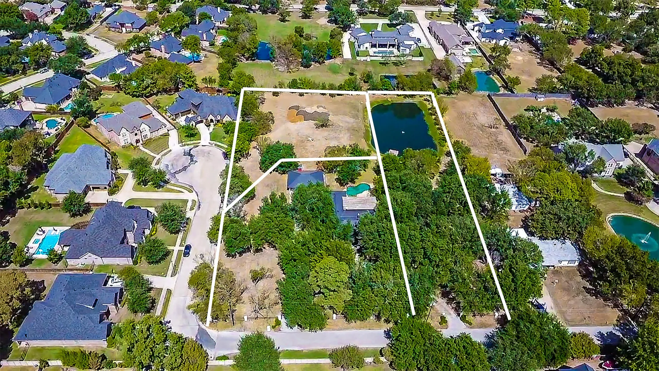 Expansive property featuring a private pond, mature trees, and substantial undeveloped land