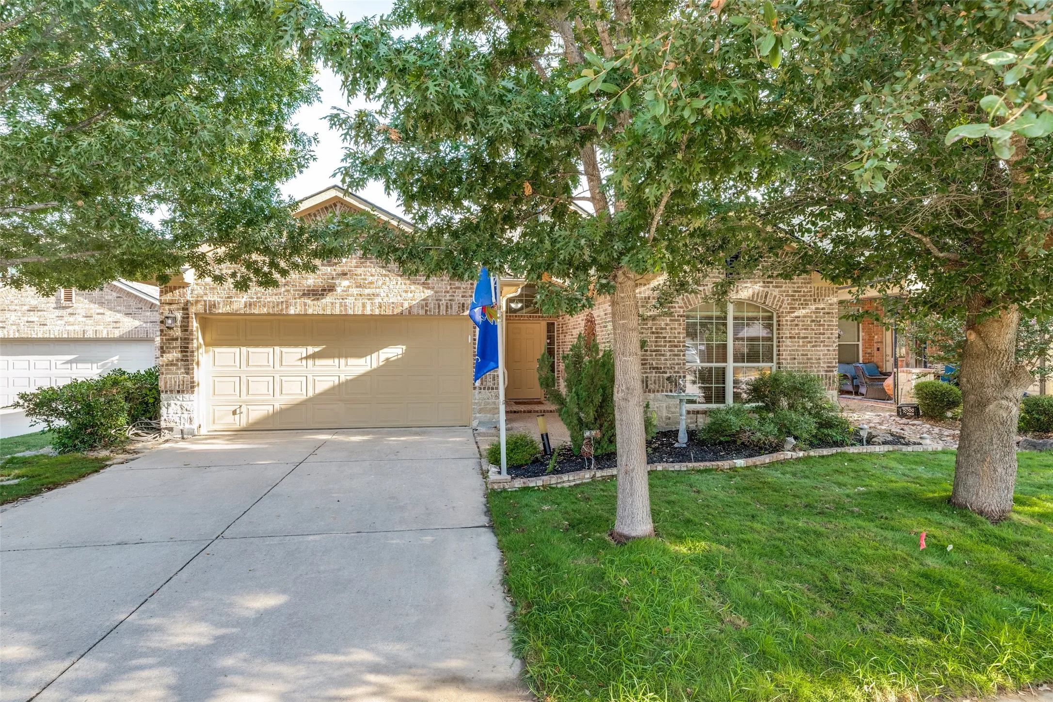 Brick exterior with an attached two-car garage, and established landscaping with mature trees