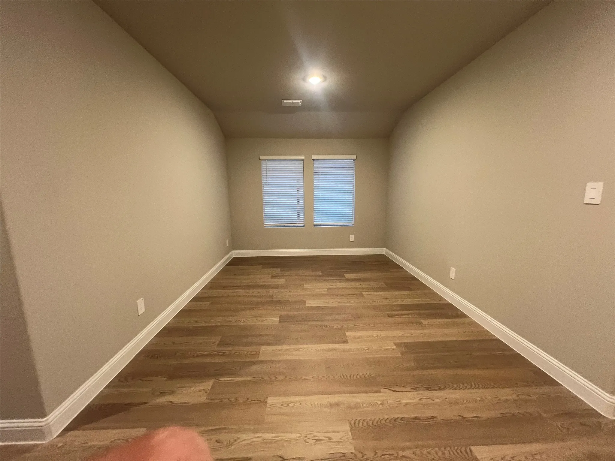 Recessed ceiling light, wood-finish flooring, neutral wall tones, window blinds, white trim