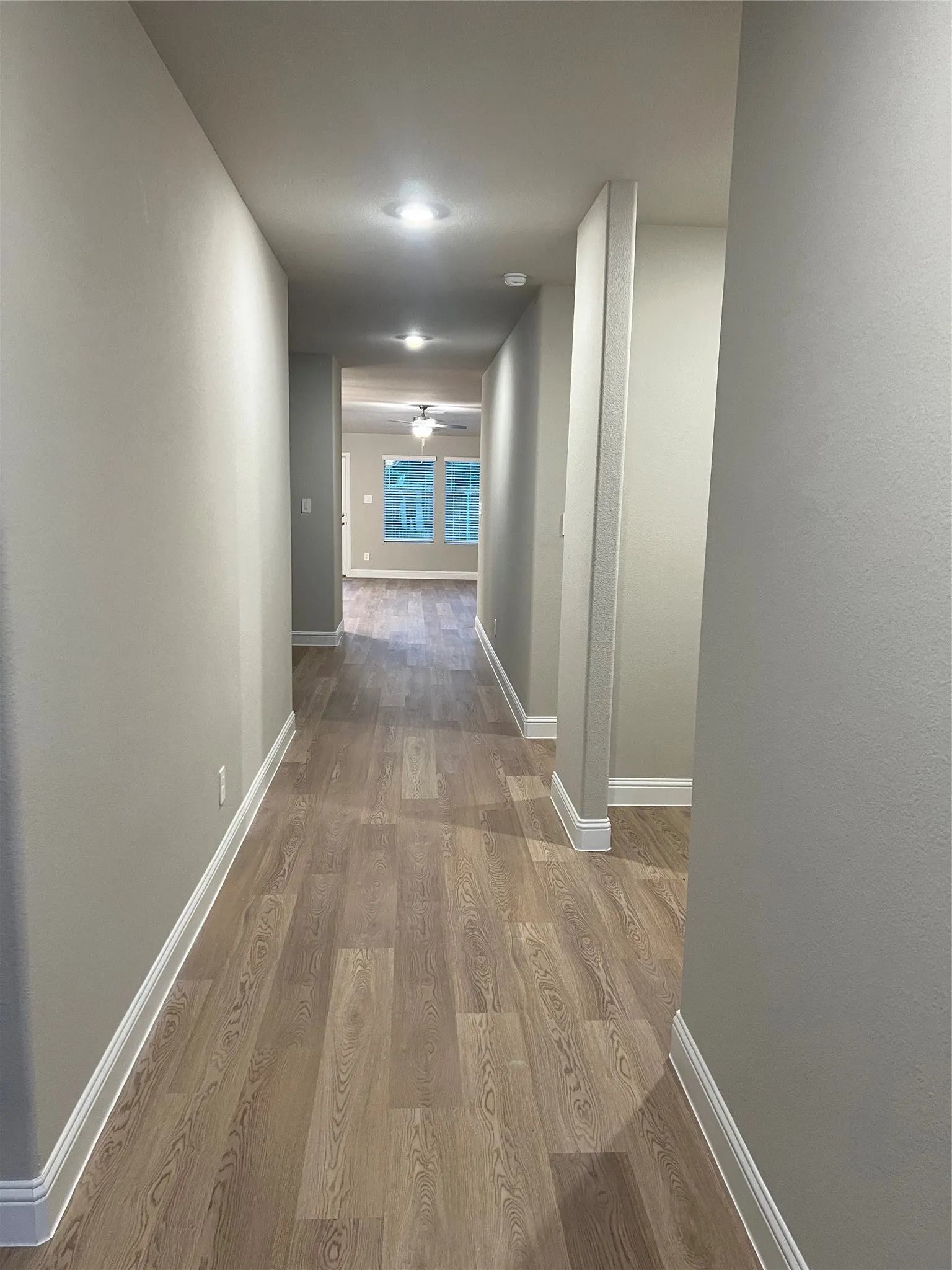 Hallway with wood-finish flooring, recessed lighting, and neutral wall tones