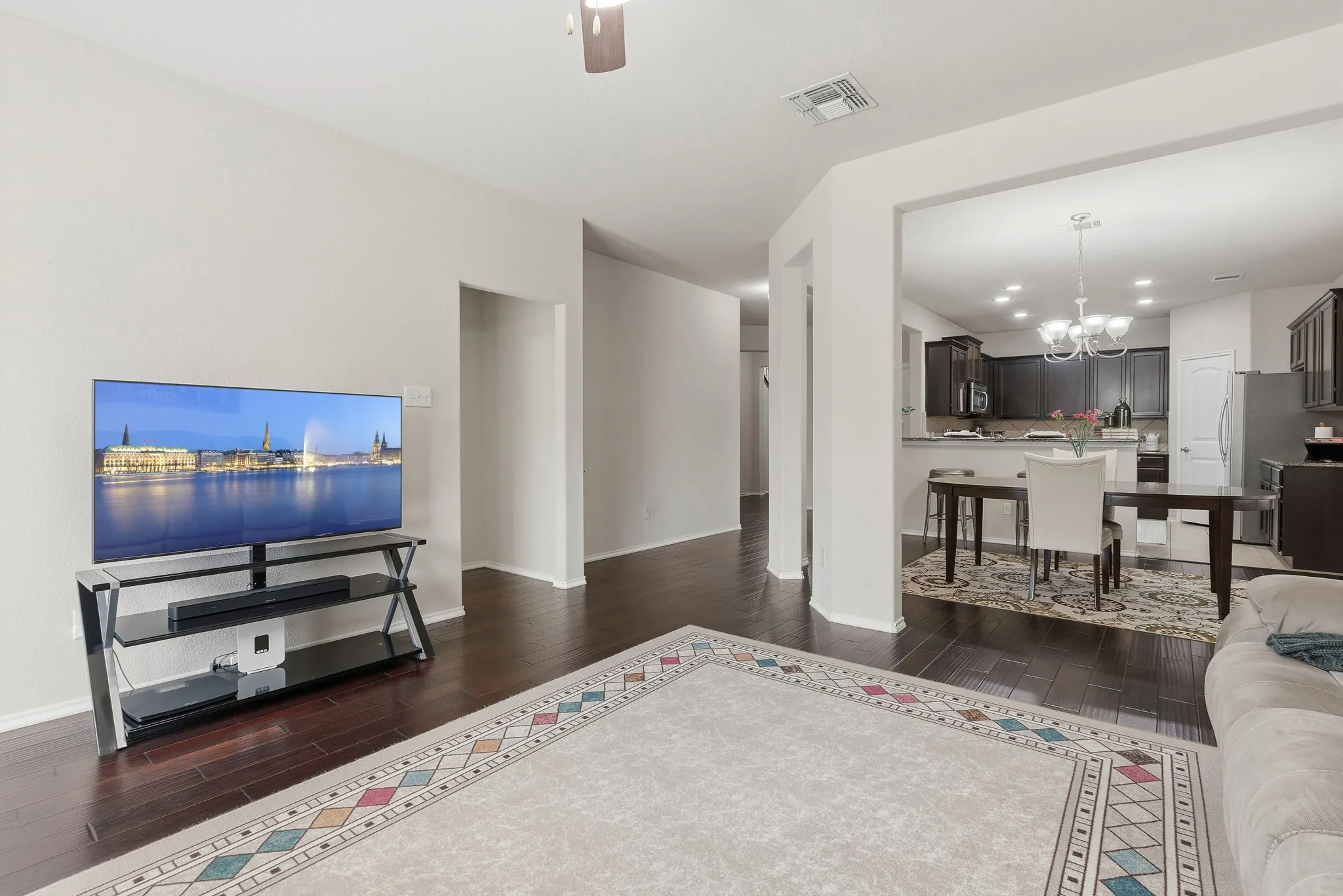 Dark wood-finish flooring throughout, recessed ceiling lighting, and an open concept layout