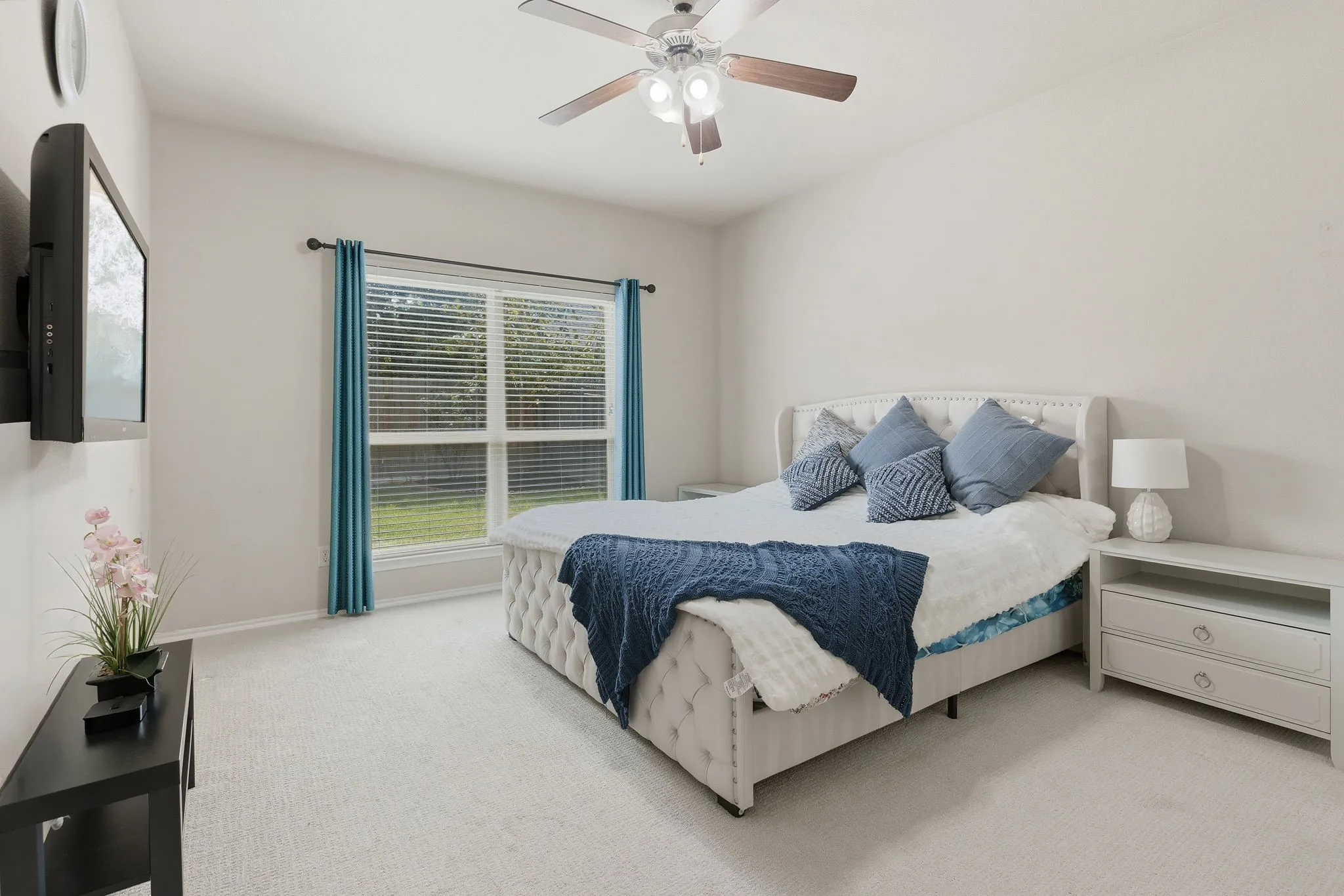 Carpeted flooring, ceiling fan, and window with blinds