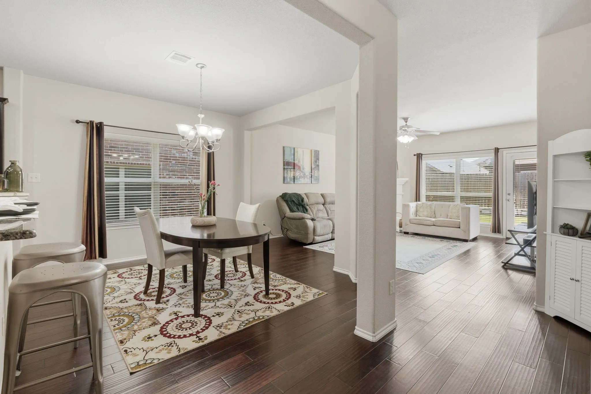 Dark wood-finish flooring, recessed lighting, and a modern chandelier