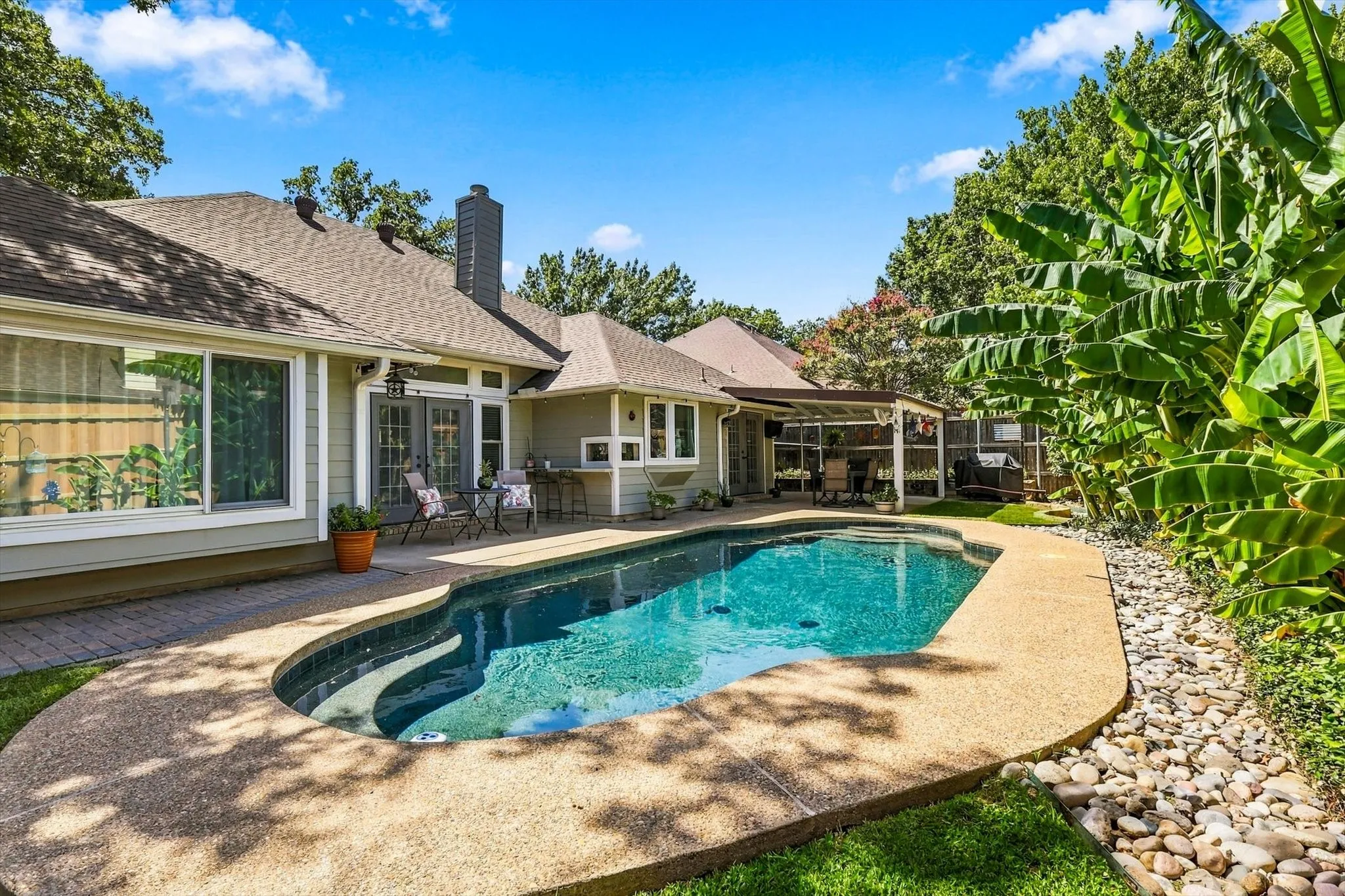Freeform swimming pool with a surrounding aggregate deck