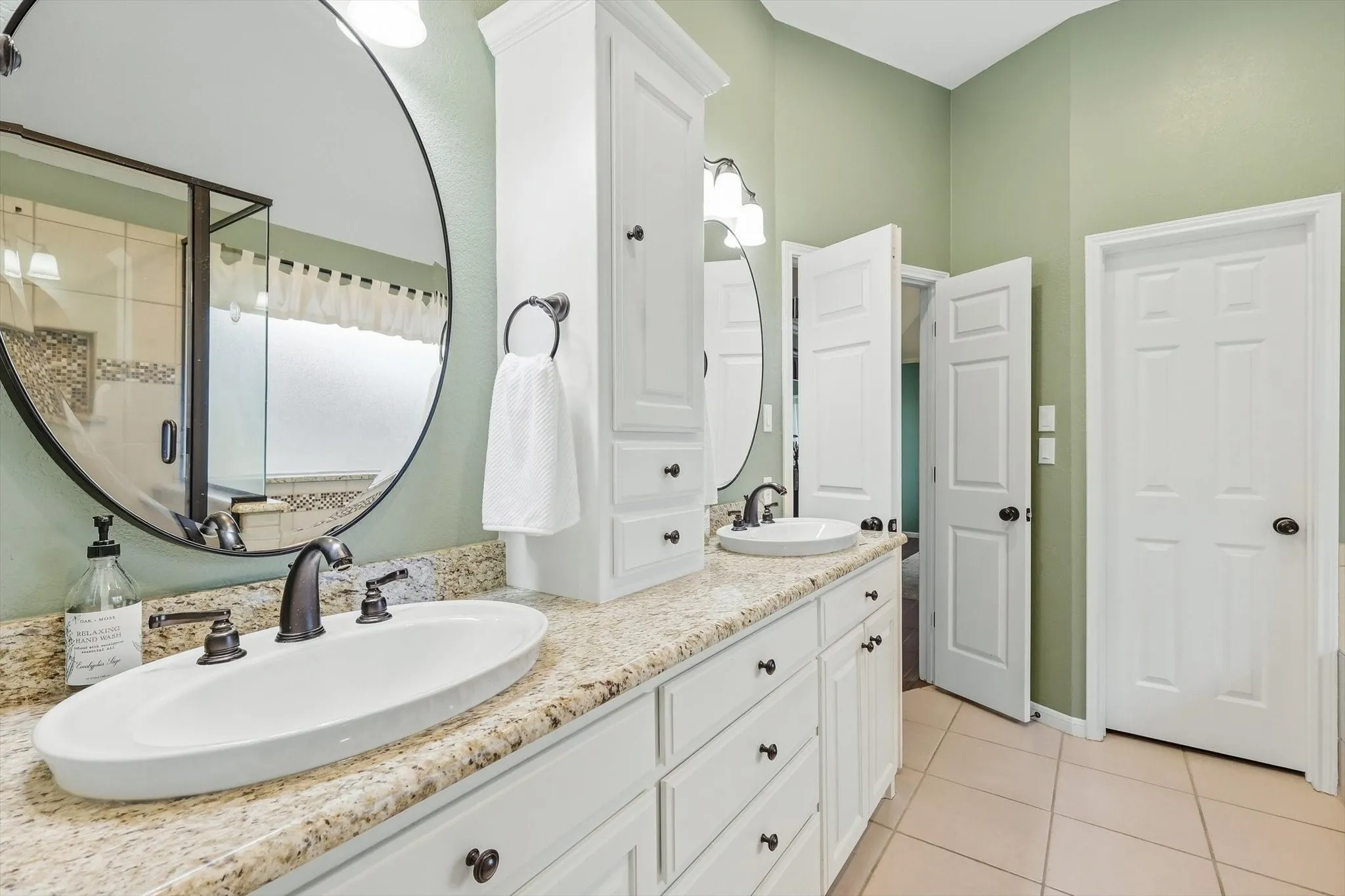 Dual vanity with integrated oval sinks, dark bronze fixtures, and light-toned speckled countertops