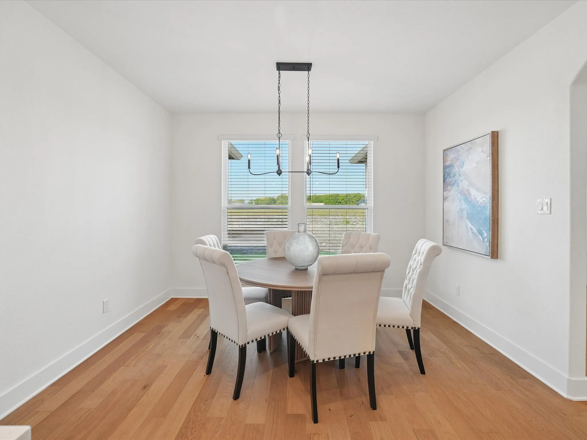 Wood-finish flooring, white walls, and a window with blinds