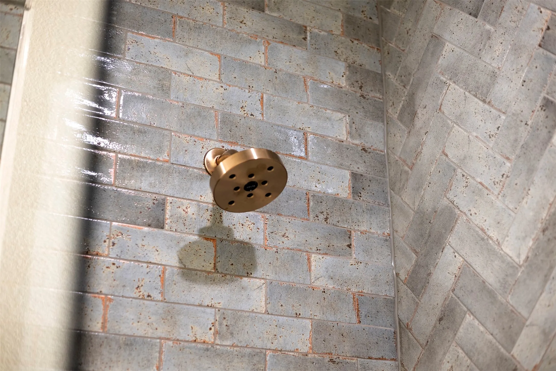 Shower featuring a round bronze-finish shower head