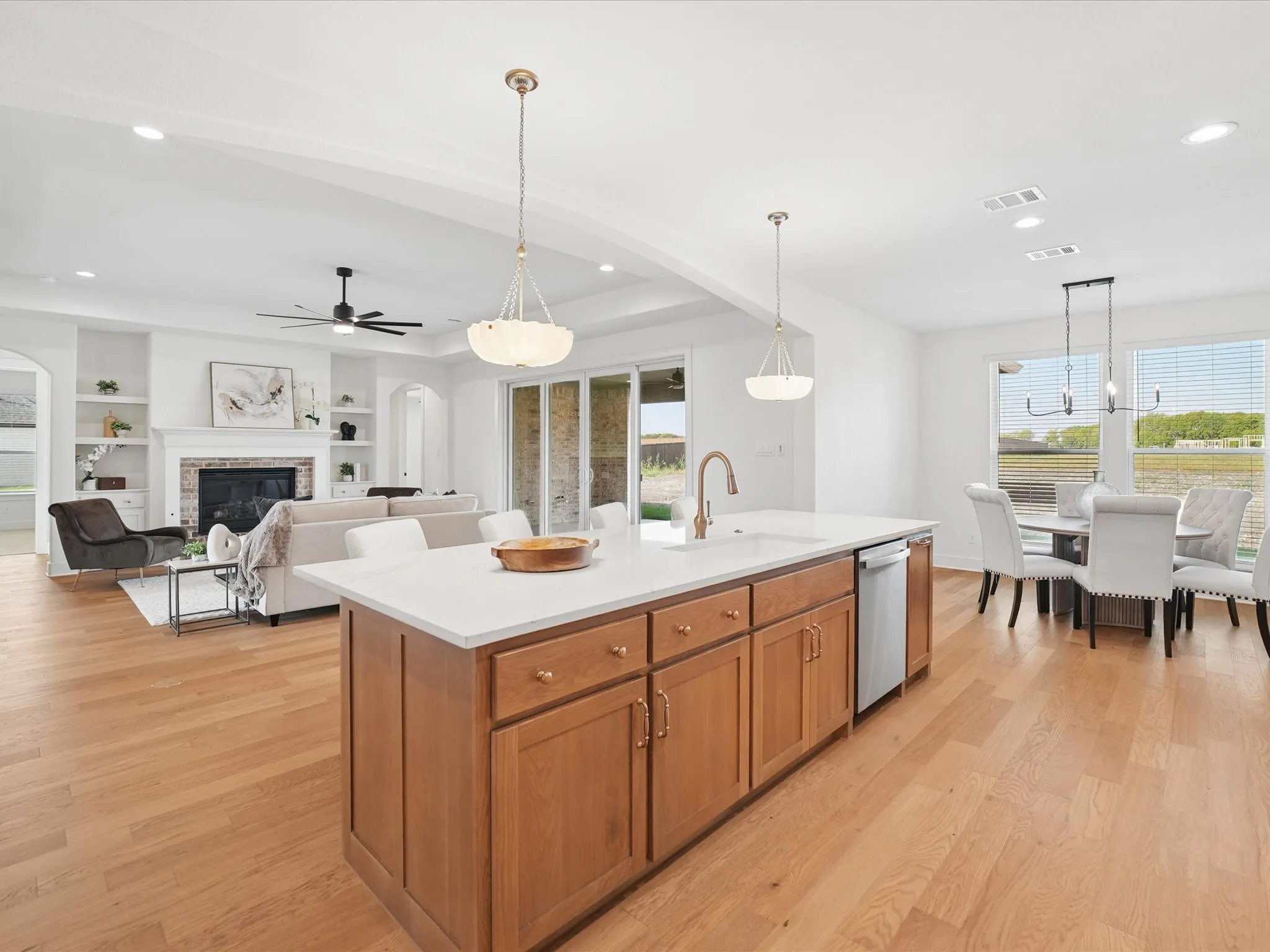 Kitchen island featuring wood cabinetry, white countertop, and integrated dishwasher