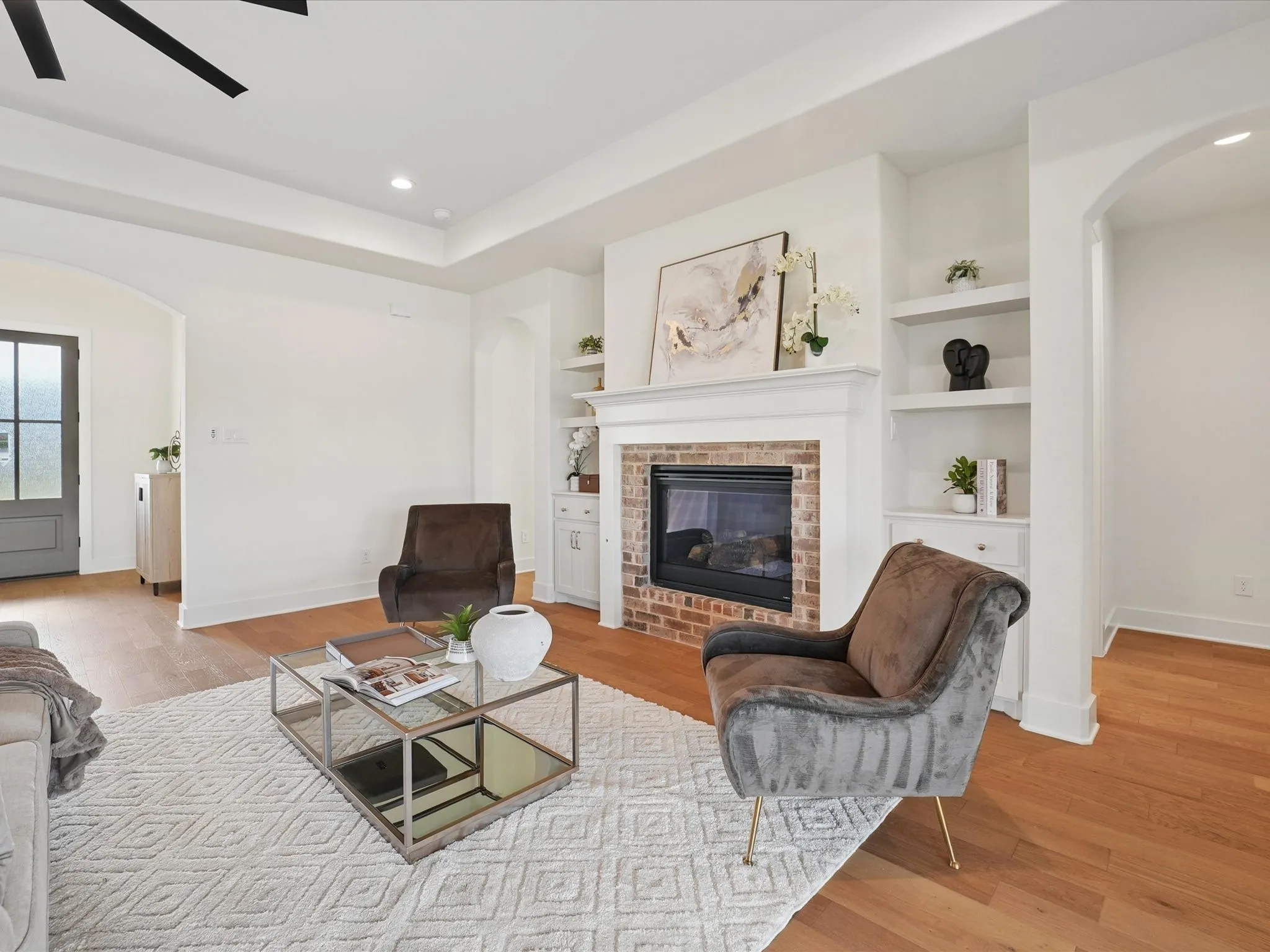 Wood-finish flooring with a tray ceiling and recessed lighting