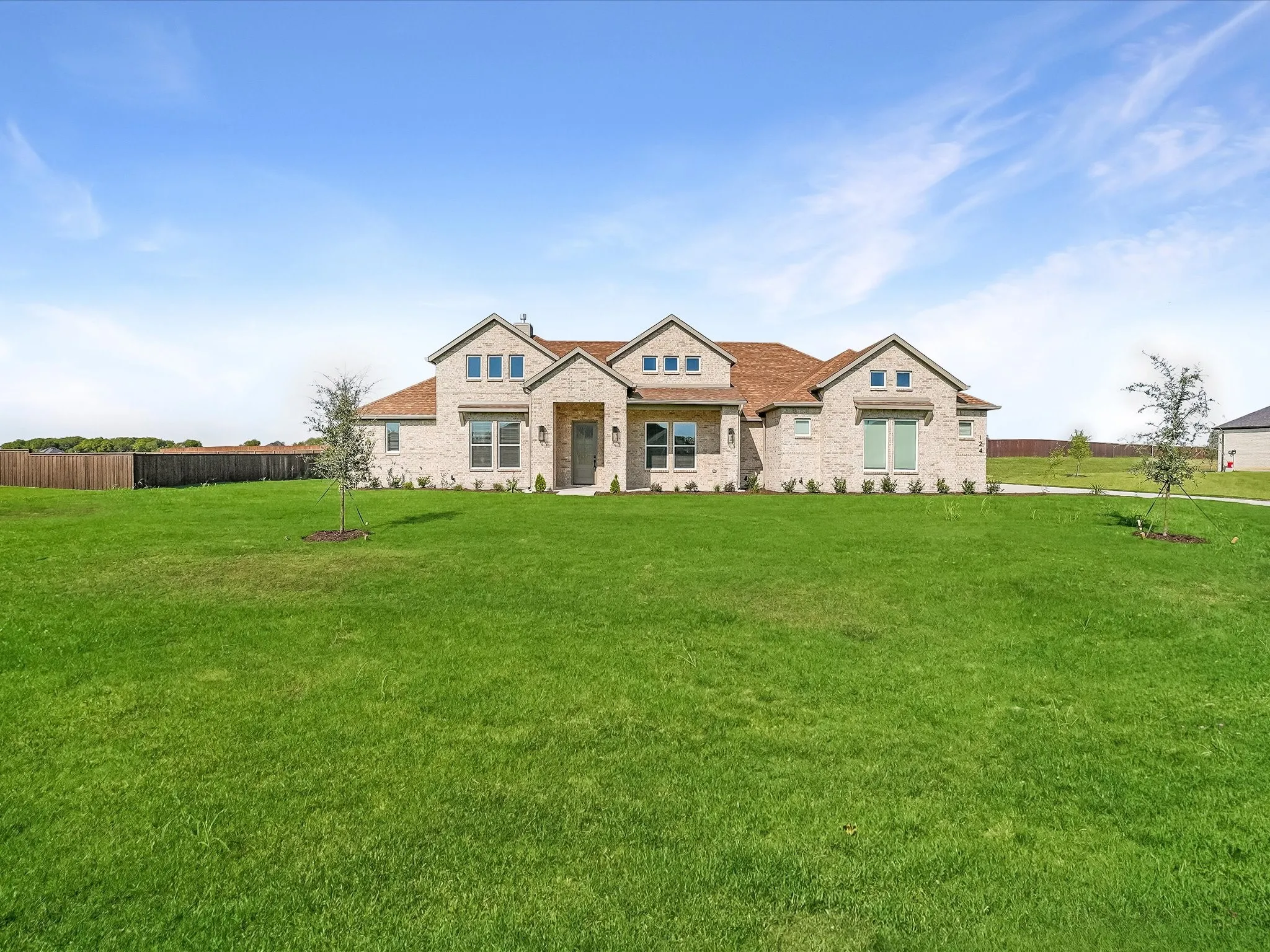 Stone brick facade home with a shingle roof and multiple gabled dormers