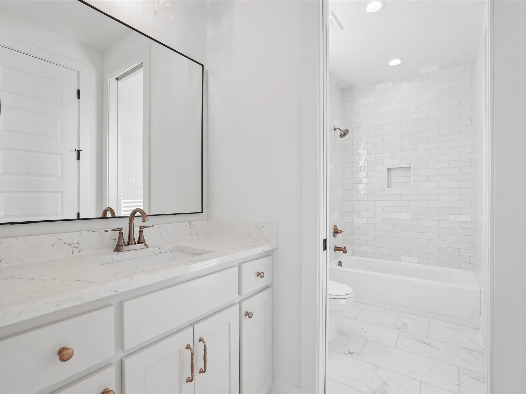 White cabinetry with bronze hardware, quartz countertop, and undermount sink