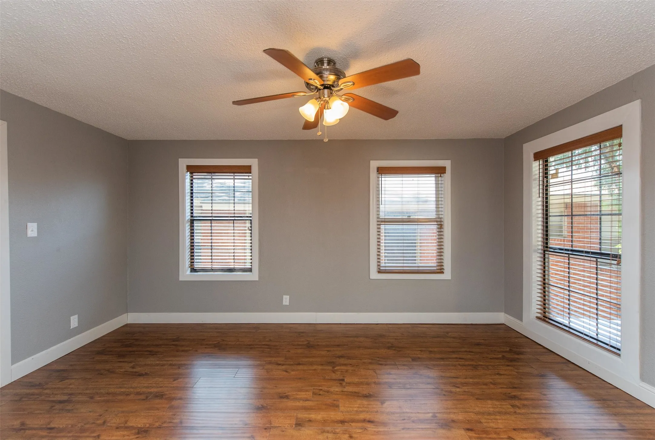Unfurnished room with a textured ceiling, ceiling fan, and hardwood / wood-style floors