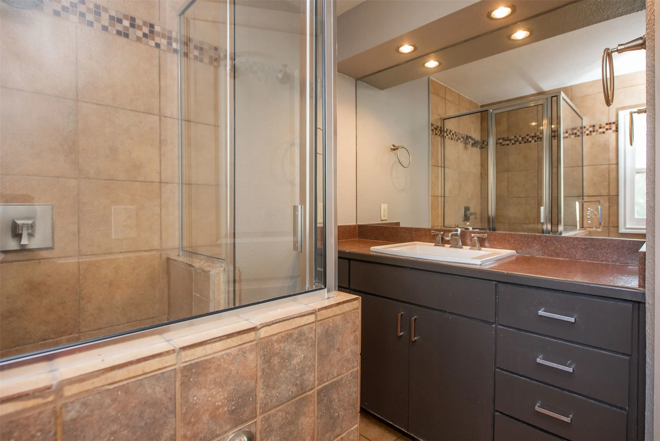 Bathroom with a shower with shower door and vanity