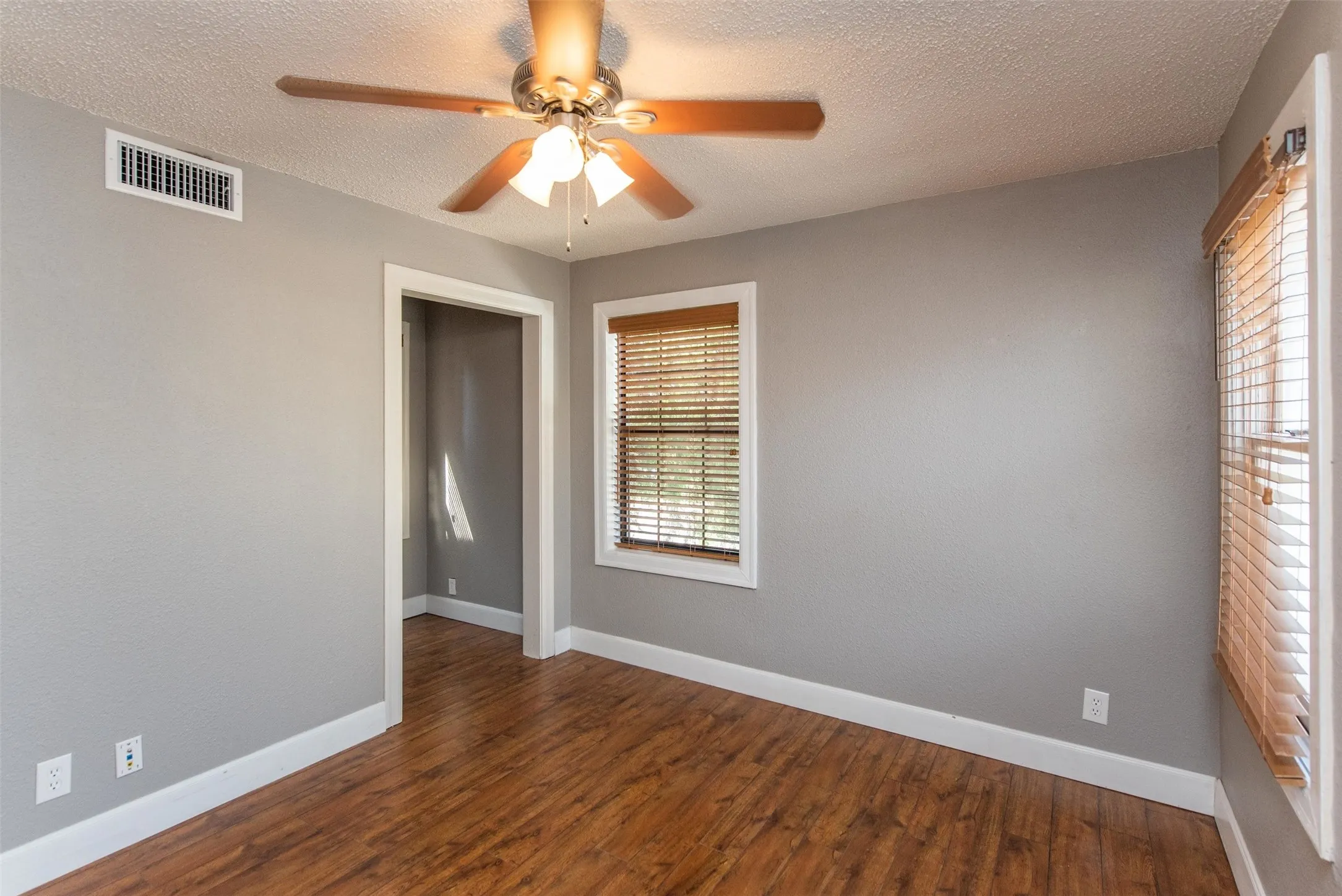 Spare room with wood-type flooring, a textured ceiling, and ceiling fan