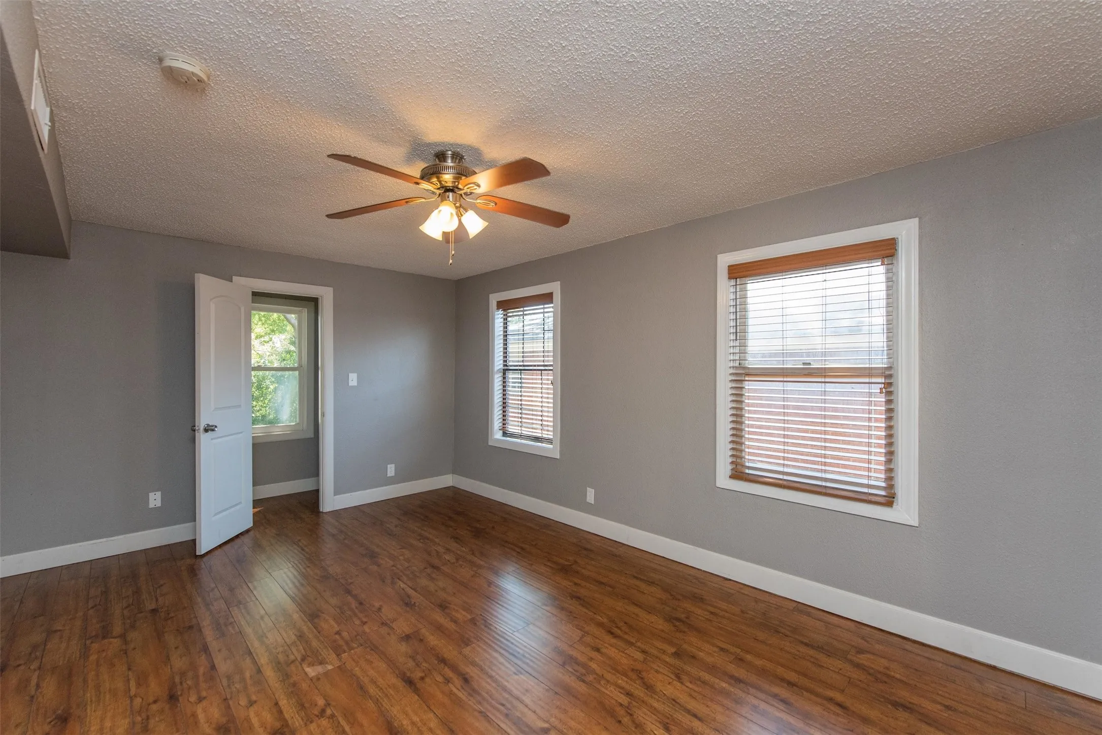 Spare room with a textured ceiling, hardwood / wood-style floors, and ceiling fan