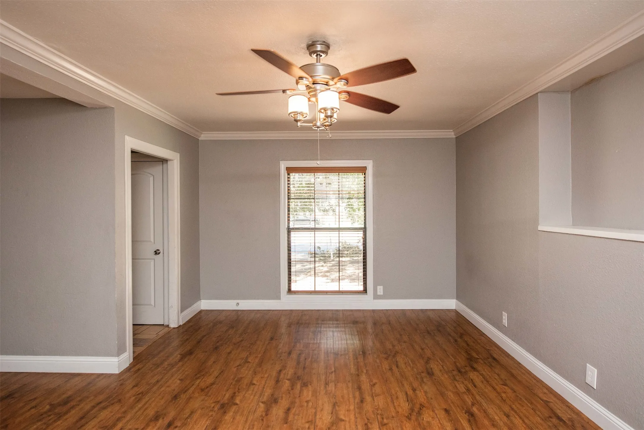 Unfurnished room with hardwood / wood-style flooring, crown molding, and ceiling fan
