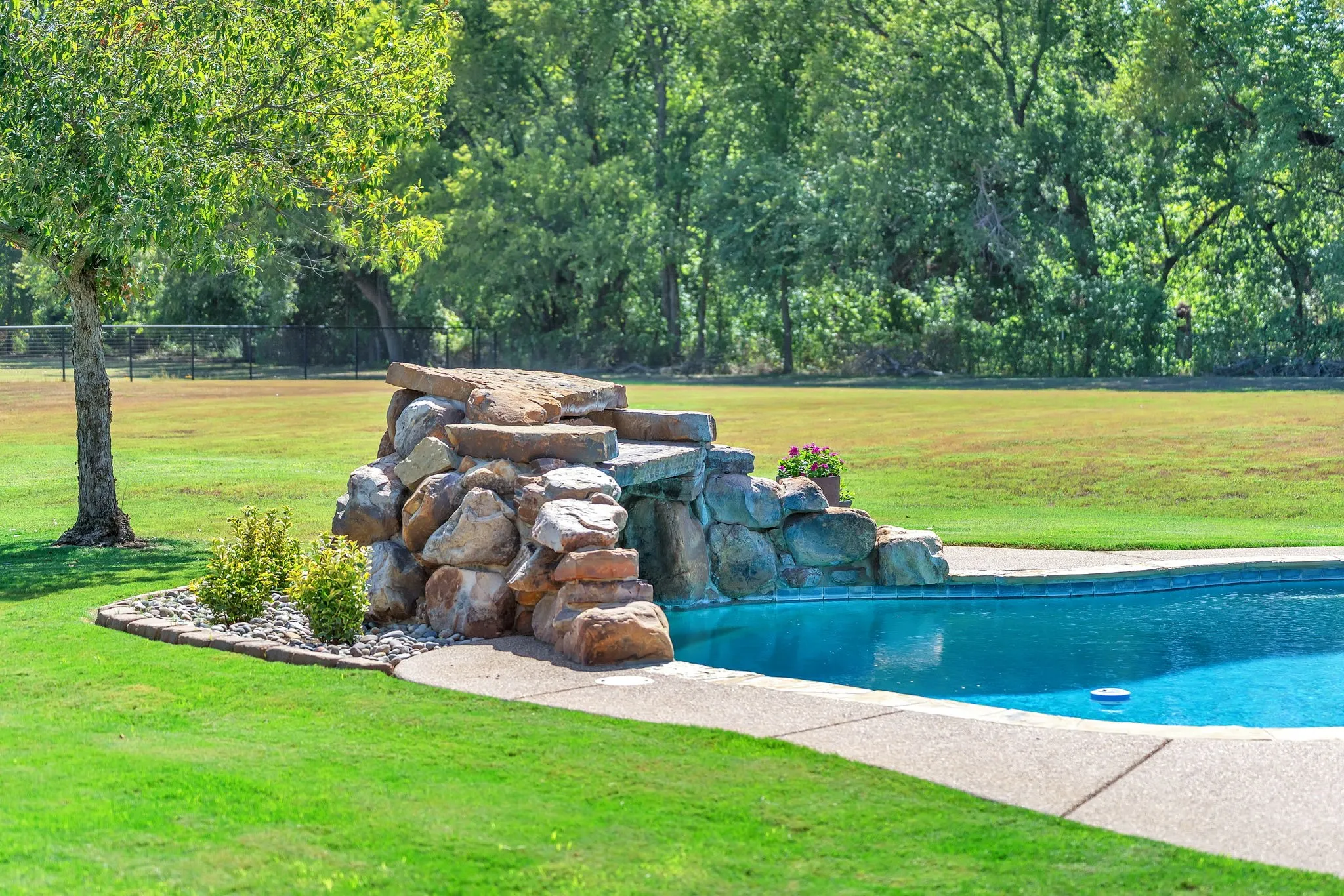 Beautiful stone waterfall to be enjoyed in and out of pool
