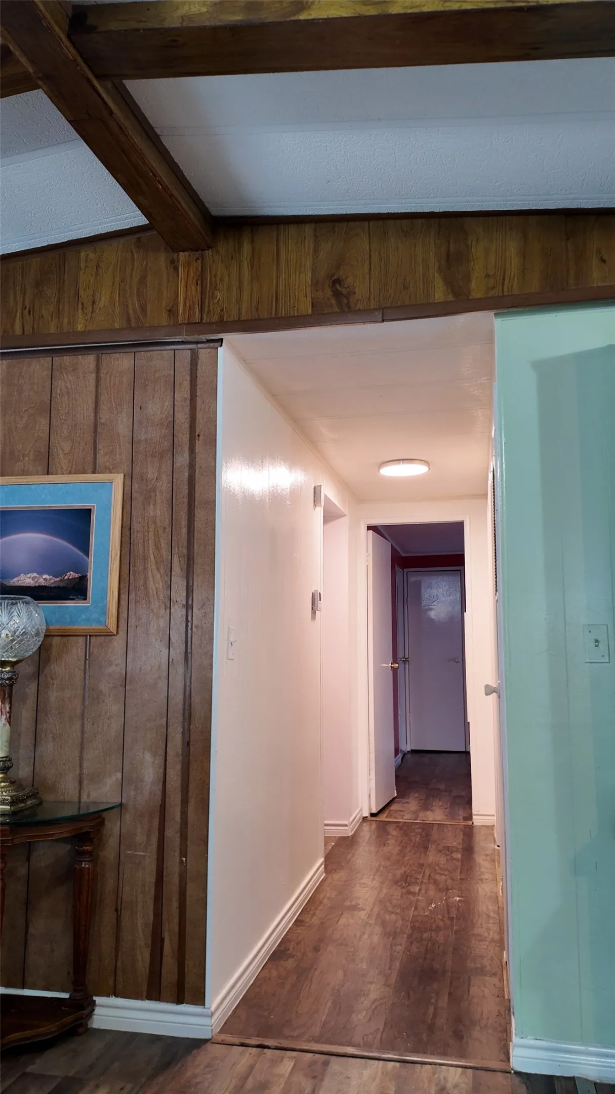 Wood-finish flooring throughout, complemented by wood paneling and exposed wood beams