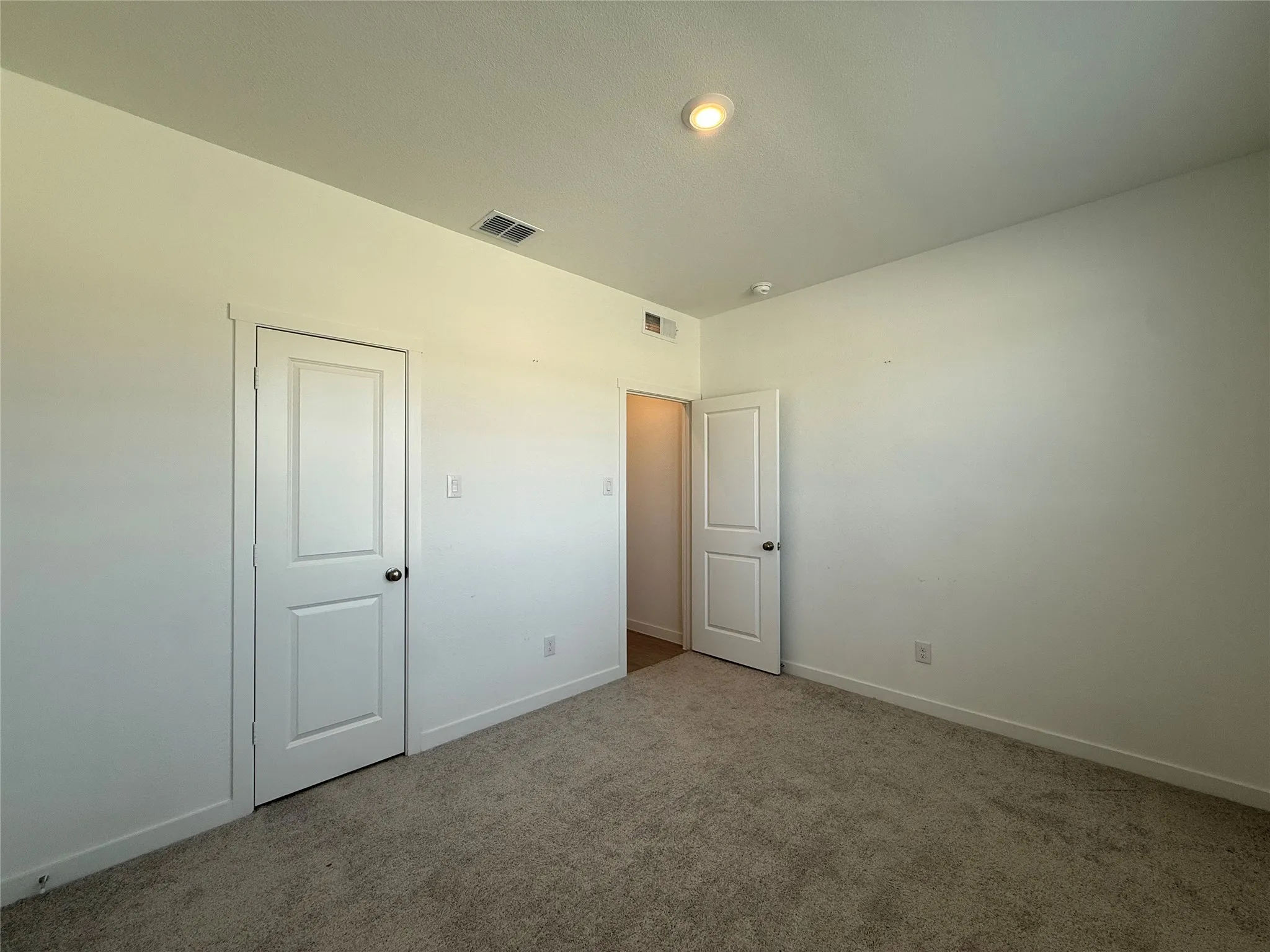 Neutral wall finishes, recessed lighting, and carpeted flooring