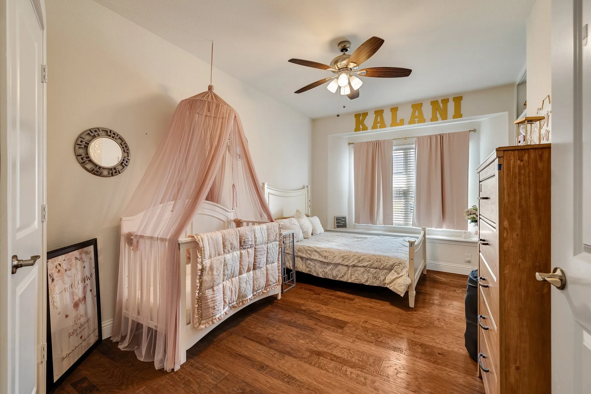 Hardwood-style flooring extends throughout the room, complemented by a ceiling fan with integrated lighting