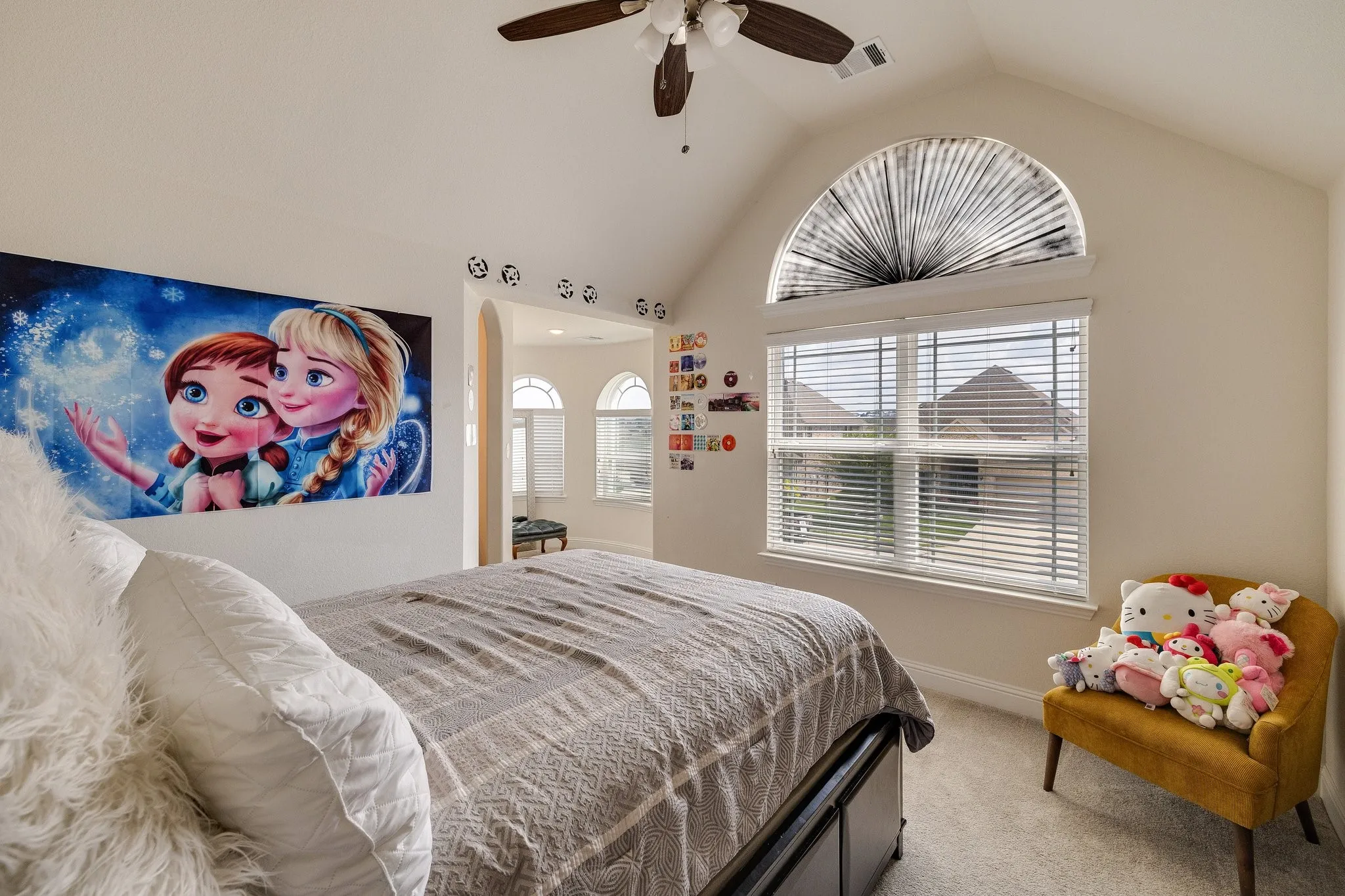 Vaulted ceiling with a ceiling fan, arched window with blinds, and carpeted flooring