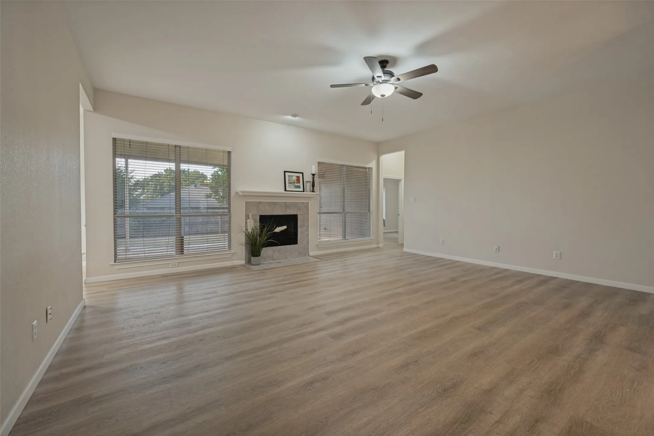 Living room with two large window to the back yard and entrance to primary bedroom.