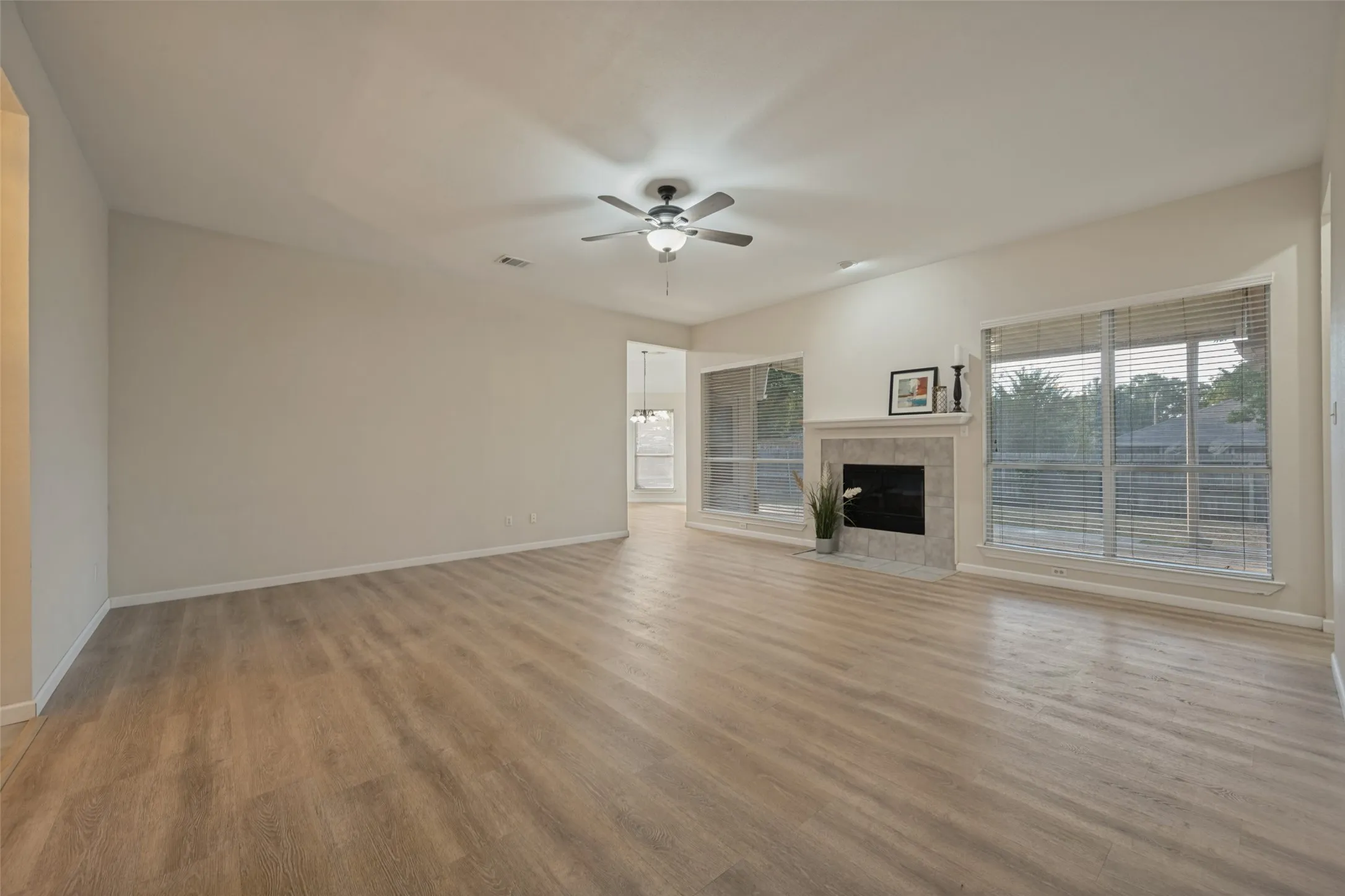 Living room with woodburning fireplace and looking into the kitchen.