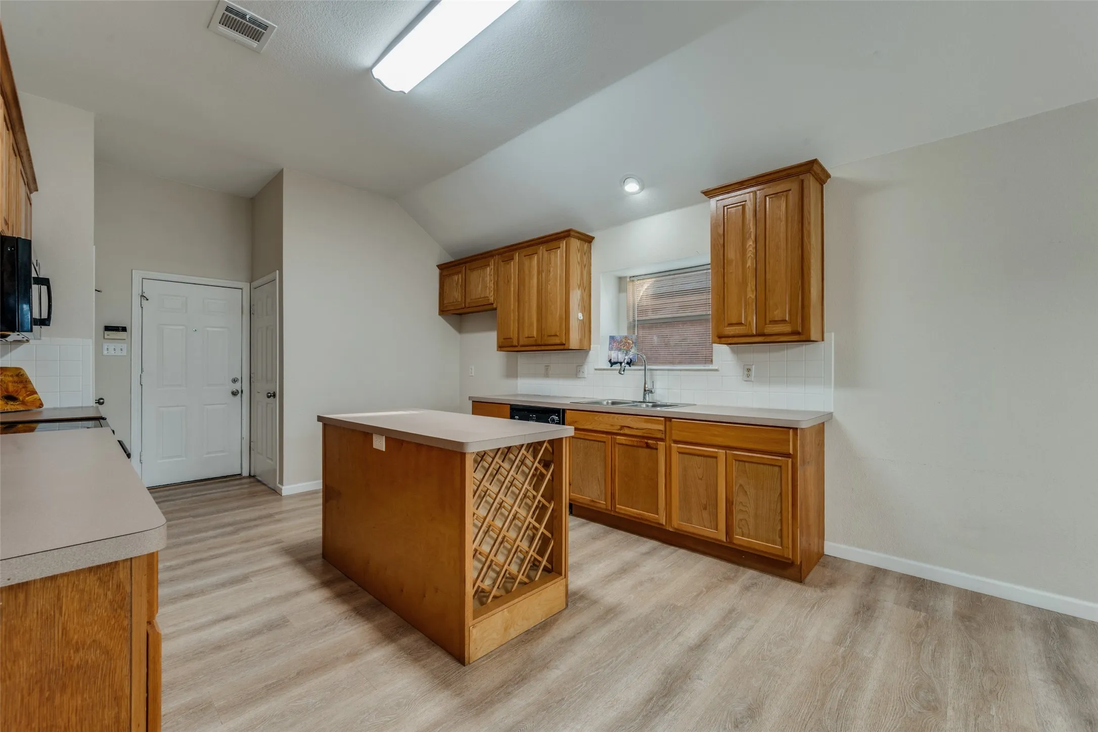 Kitchen with window box over the sink and showing access to the garage.