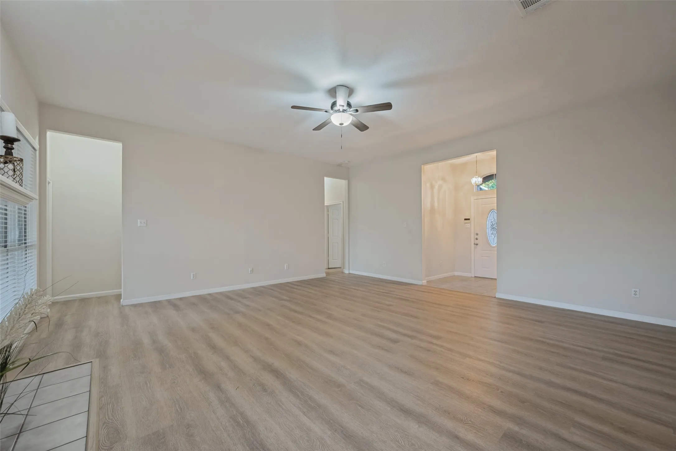 Living room showing front entry way and entrance to primary bedroom and hall to guest bedrooms