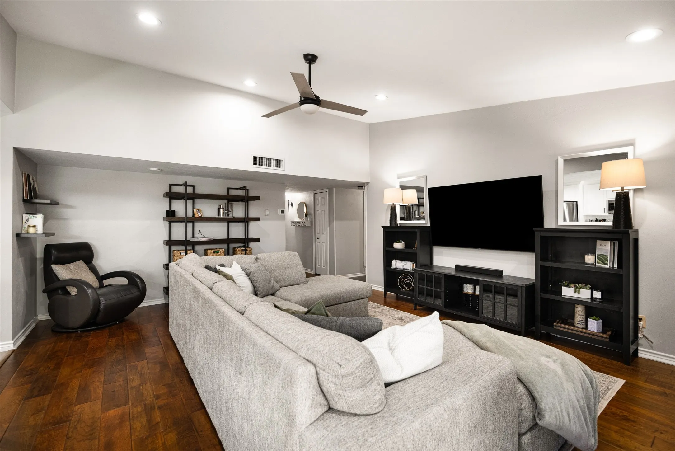 Vaulted ceiling with recessed lighting, wood-finish flooring, and a ceiling fan