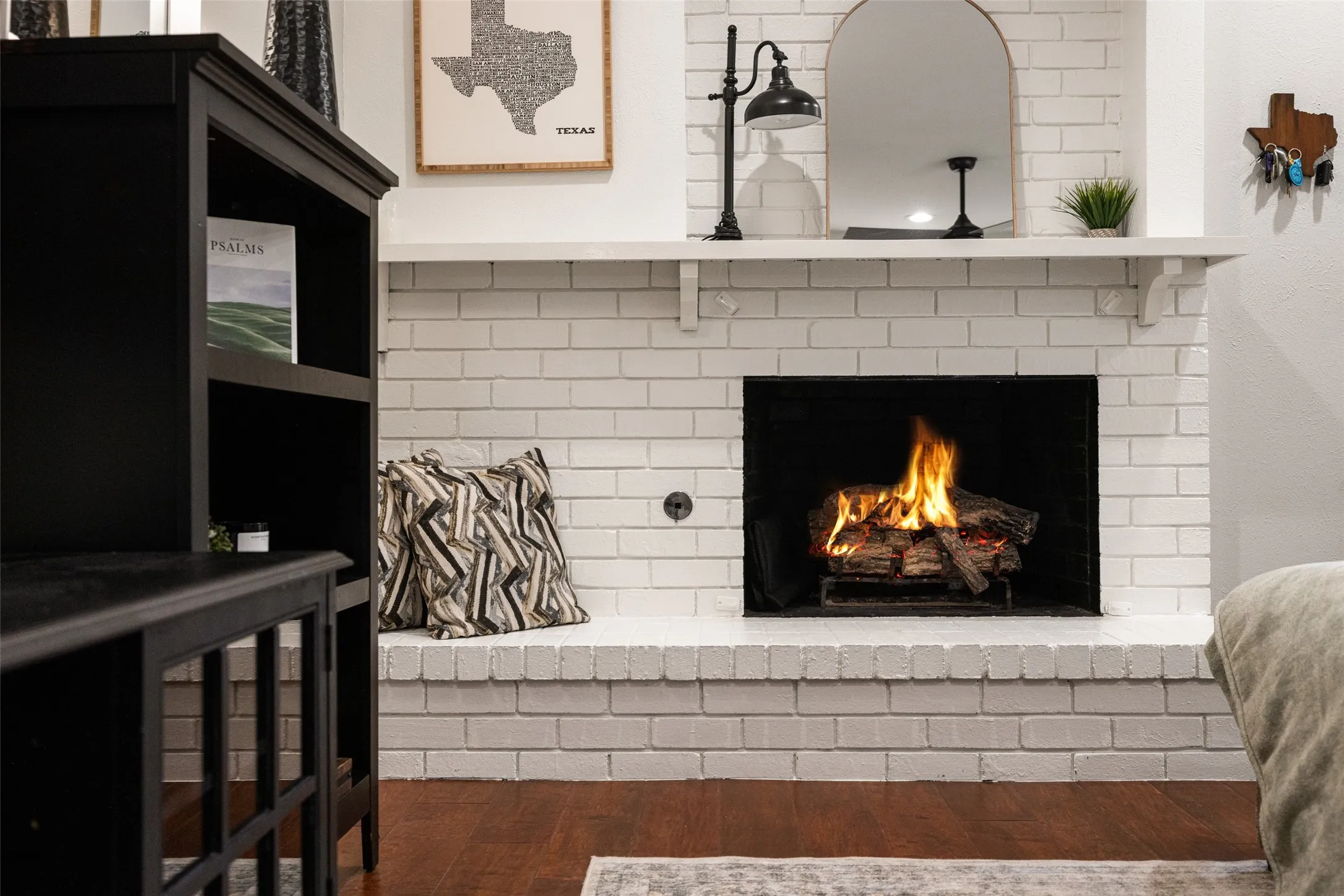 White painted brick fireplace with a substantial hearth and mantel