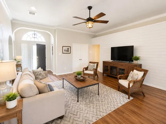 Living room with high ceiling, wood feature wall and wood-burning fireplace