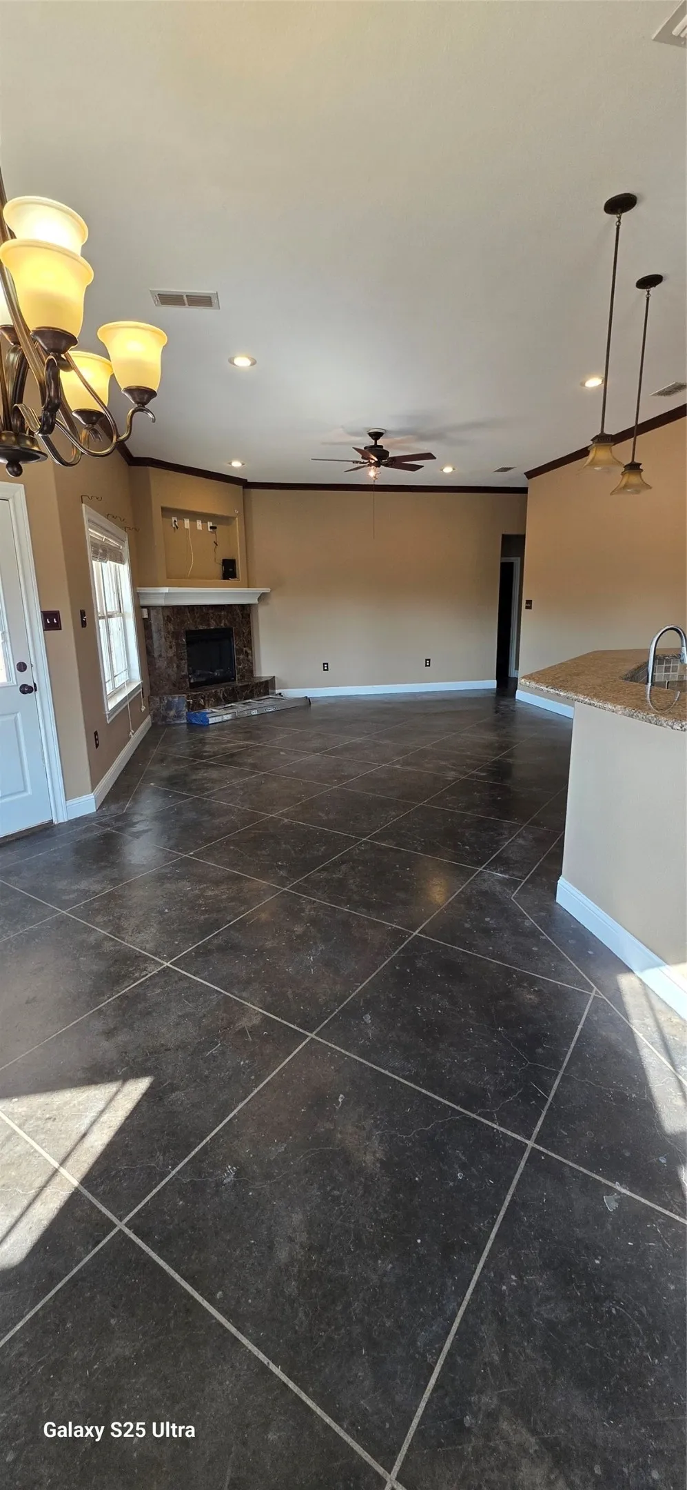 Spacious room with dark tile flooring, a fireplace featuring a stone surround and white mantle, recessed lighting, and a ceiling fan