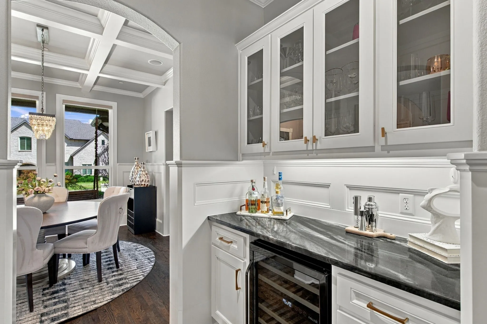 A beautifully appointed butler’s pantry connects the kitchen and formal dining room, creating an elegant transition designed for effortless entertaining. Glass-front cabinetry provides stylish display and storage, while a beverage refrigerator, generous serving counter and designer finishes make hosting everything from intimate dinners to holiday gatherings a breeze.