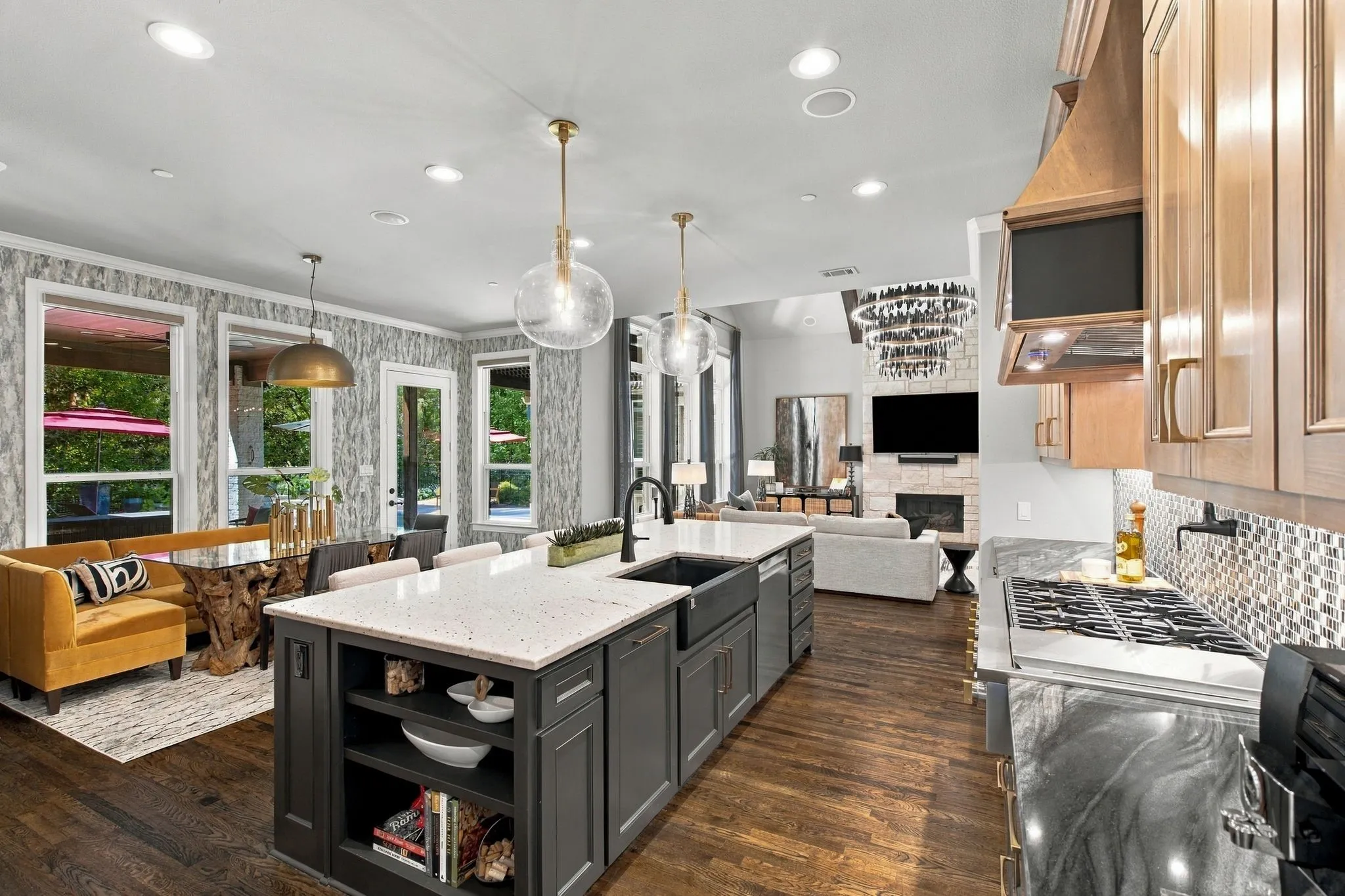 Designed for gathering, this spectacular kitchen sits at the heart of an open, light-filled floor plan where cooking, dining and entertaining come together beautifully. The oversized island commands center stage, while designer lighting, rich hardwoods and sophisticated finishes create a striking visual connection from the kitchen to the dramatic great room. Walls of windows and direct access to the covered patio and pool extend the living experience outdoors—an exceptional space made for entertaining.